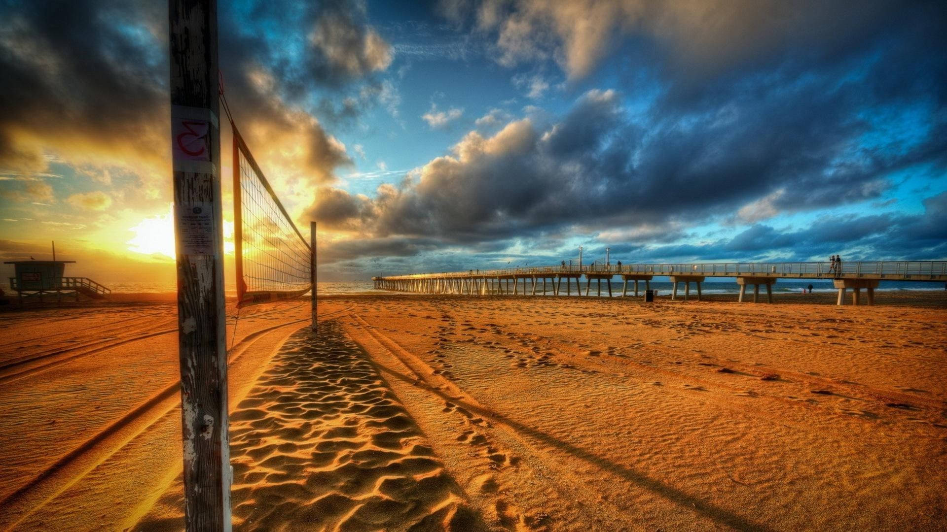 Beach Volleyball Court Near A Pier Background