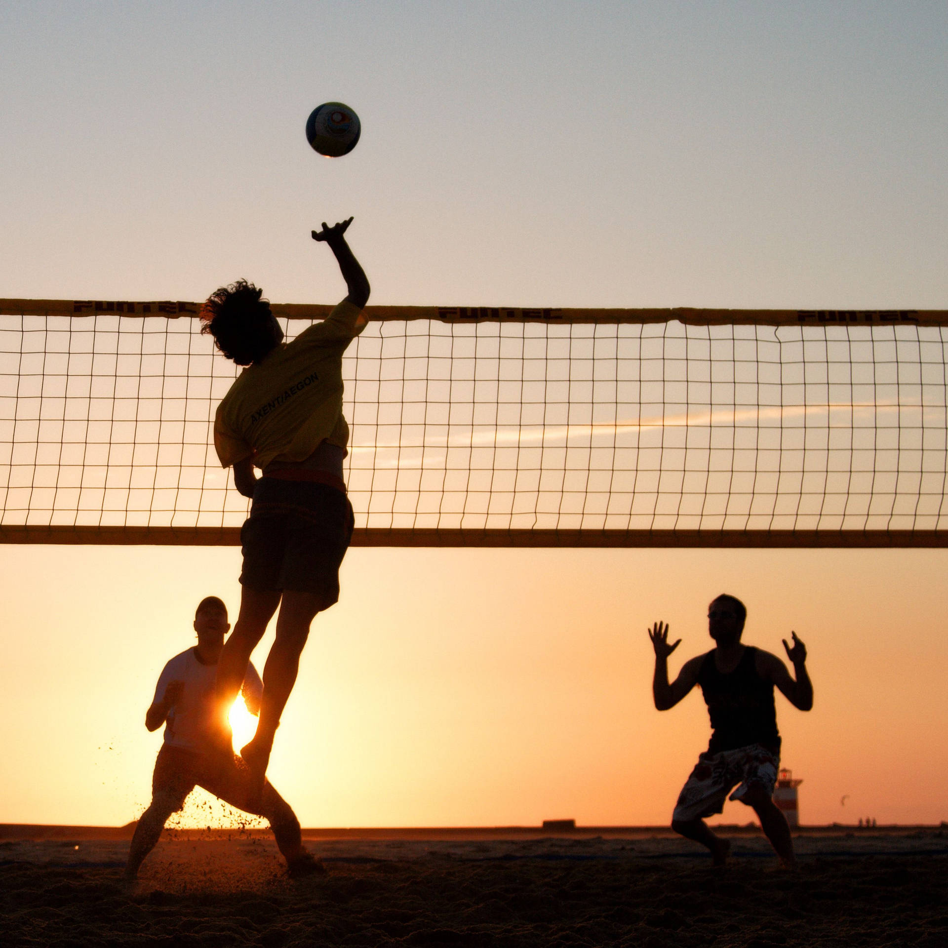 Beach Volleyball Men Silhouette At Sunset Background