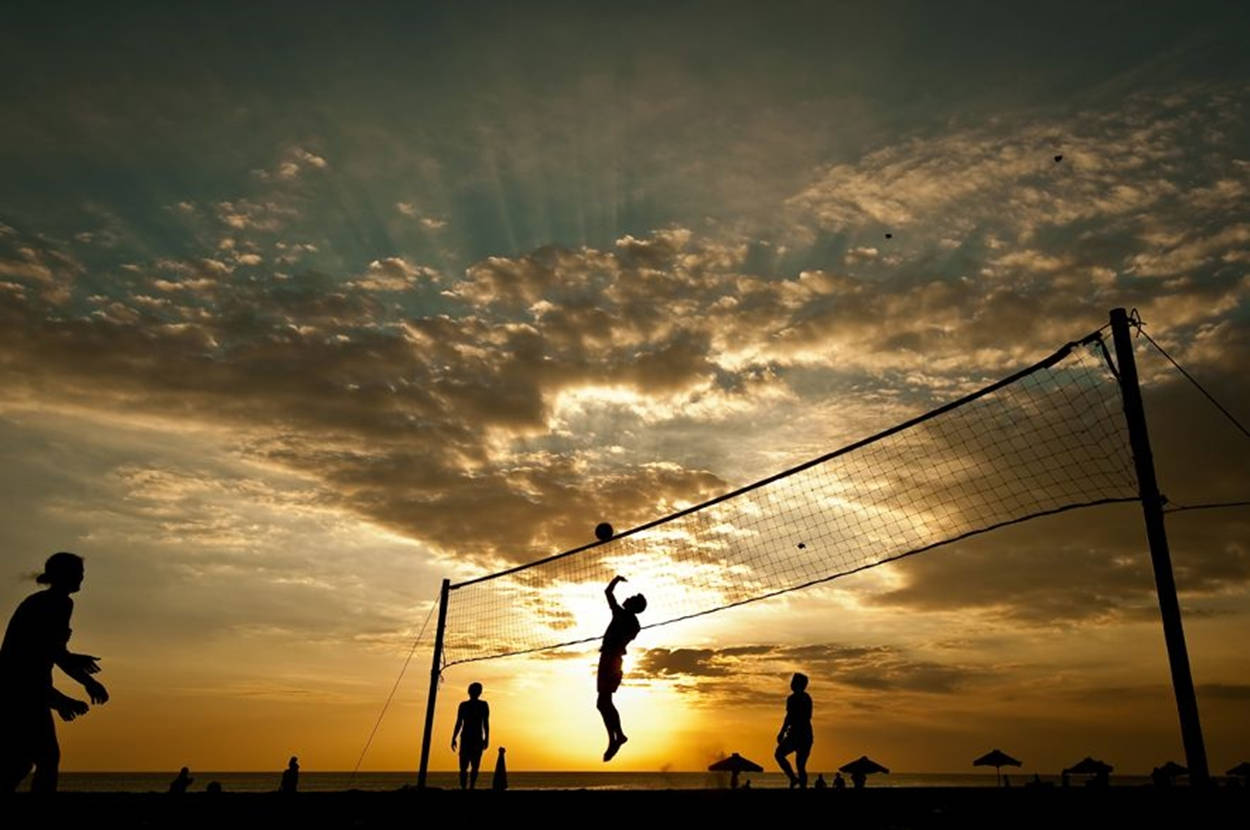 Beach Volleyball Silhouette On A Cloudy Day Background