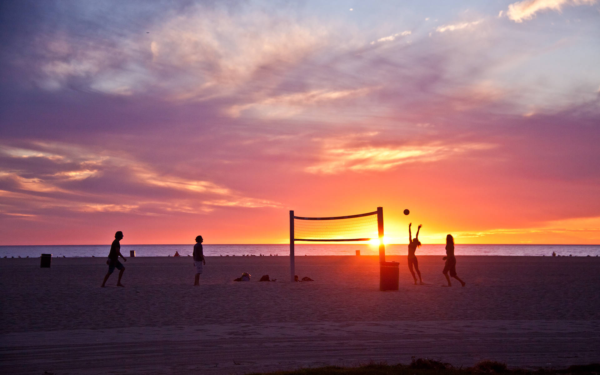 Beach Volleyball With A Setting Sun Silhouette