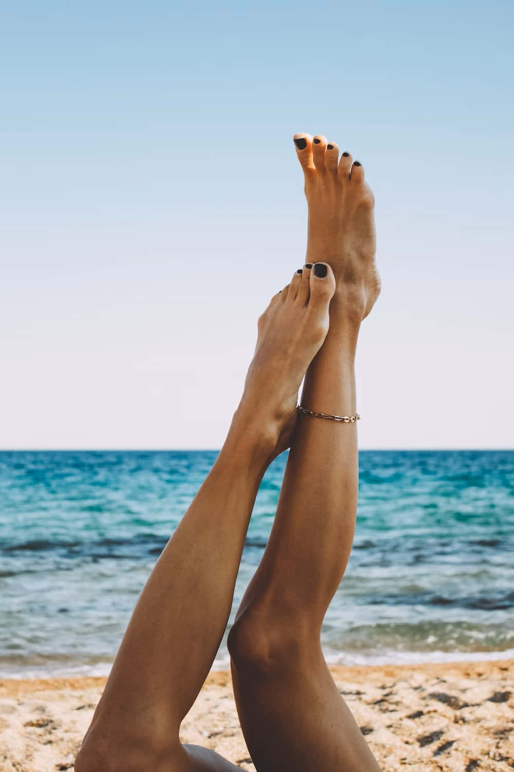 Beachside Legs Raised Against Sky Background