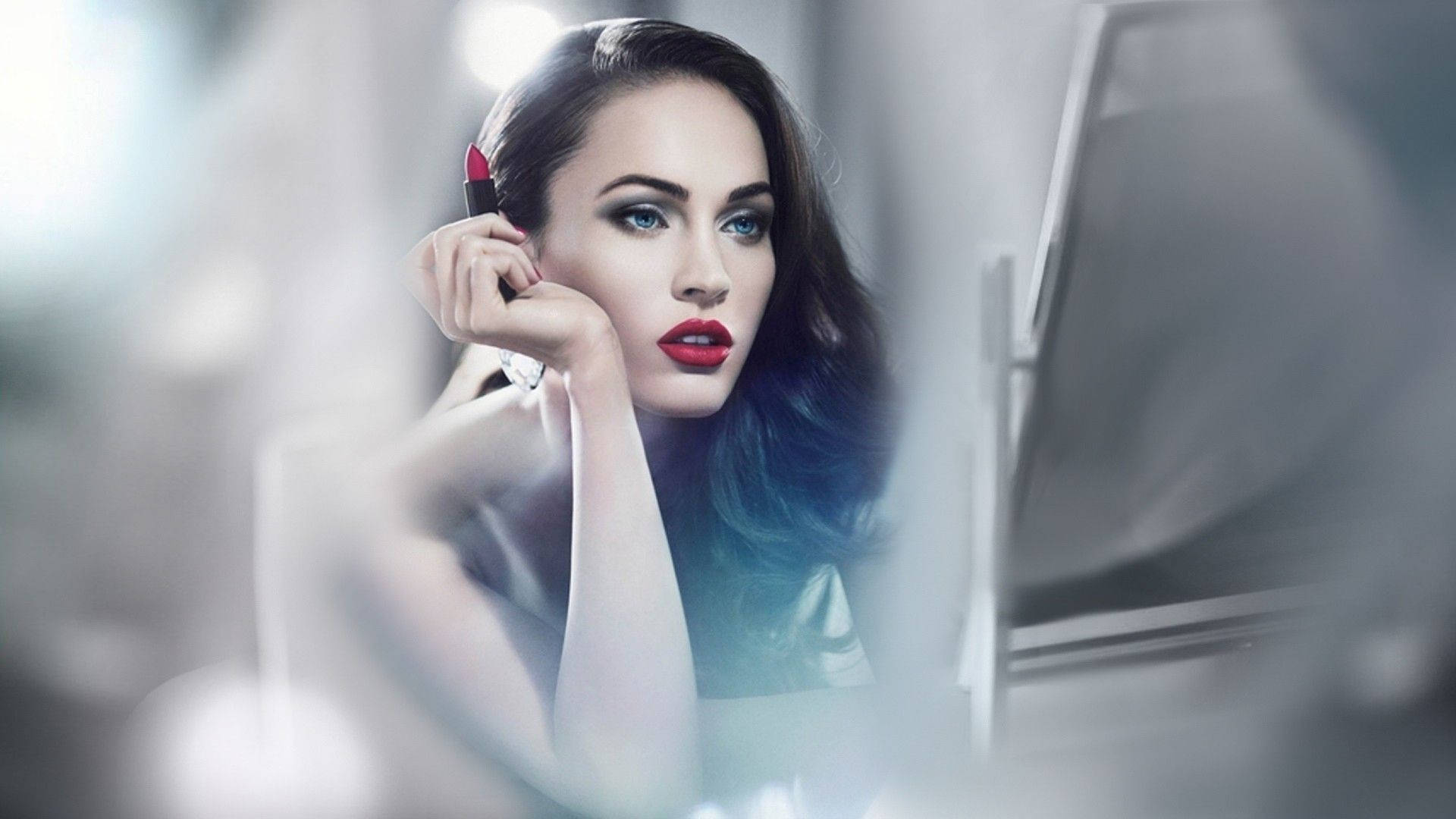 Beautiful Megan Fox Applying Red Lipstick In The Mirror Background