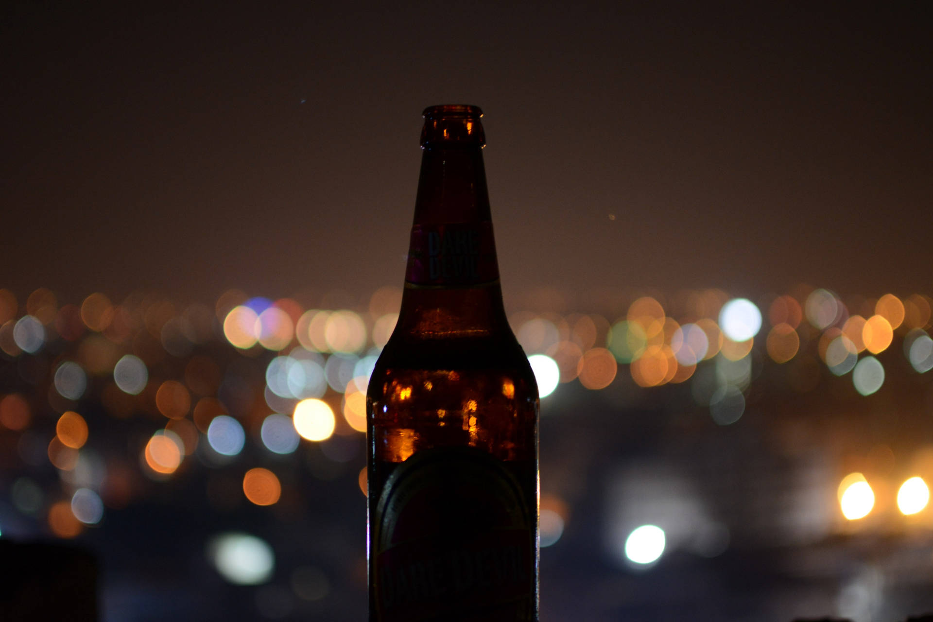 Beer Bottle And City Lights Background