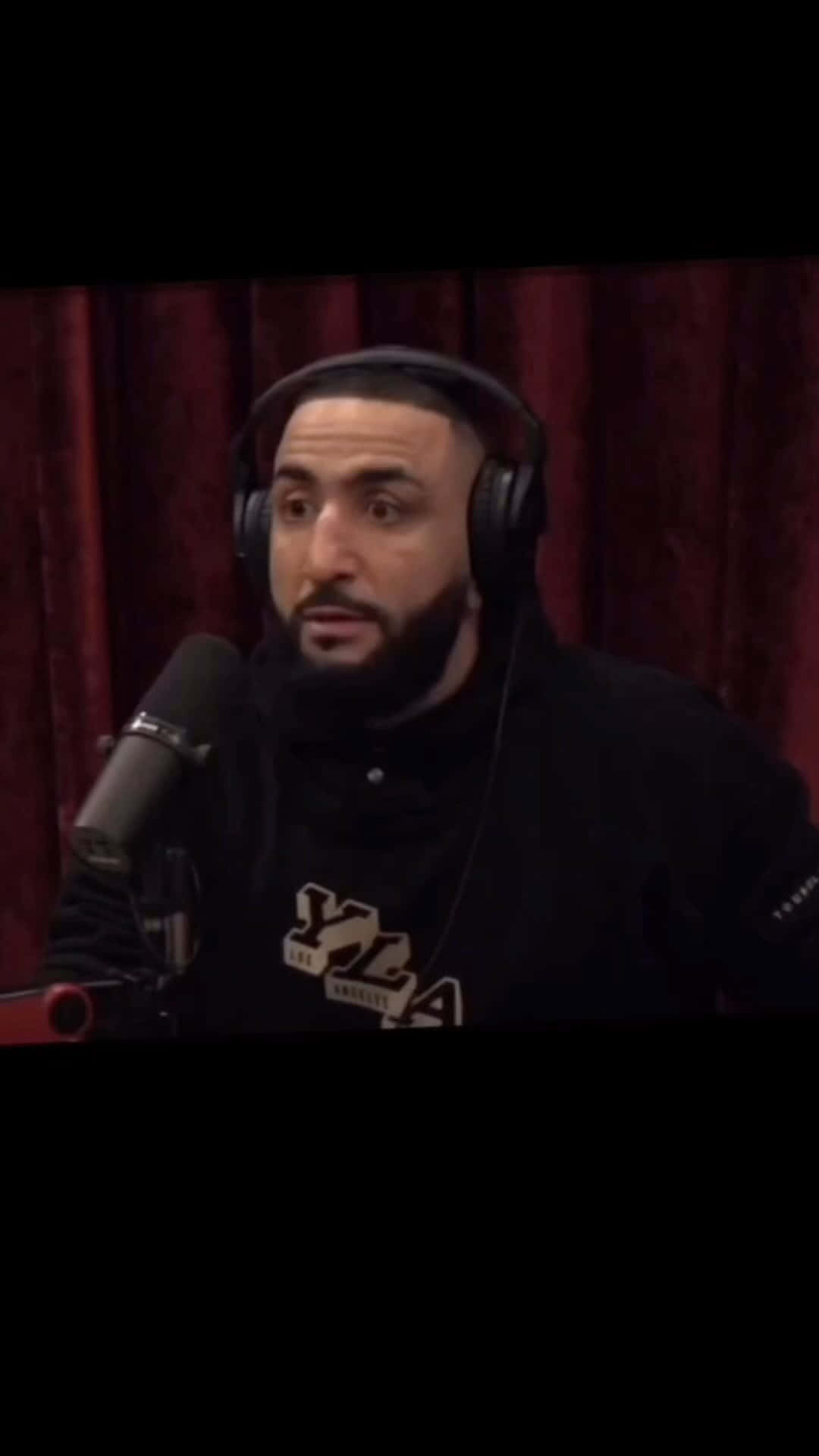 Belal Muhammad Speaking Into A Microphone Background