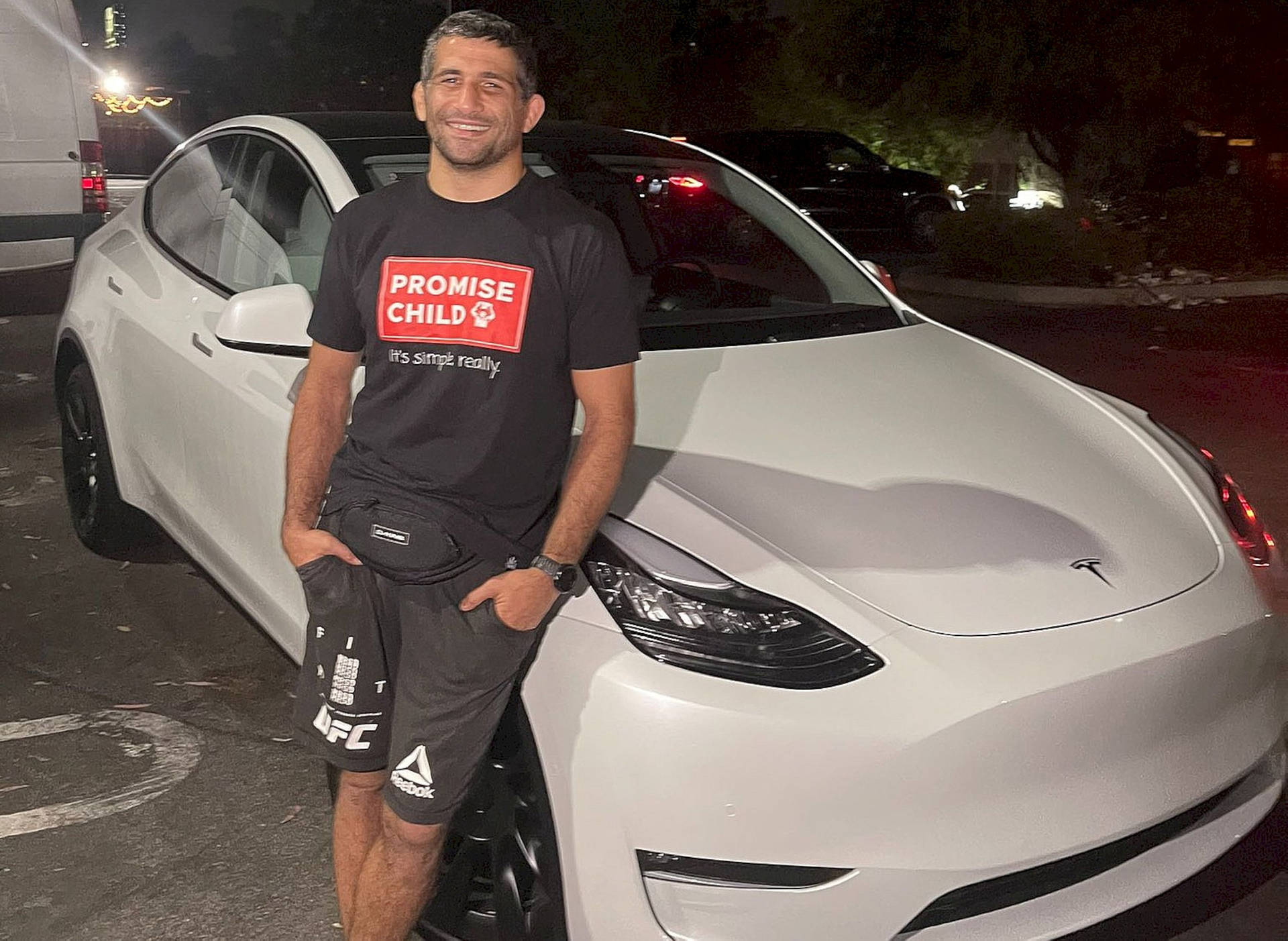 Beneil Dariush Leaning Against A Car Background