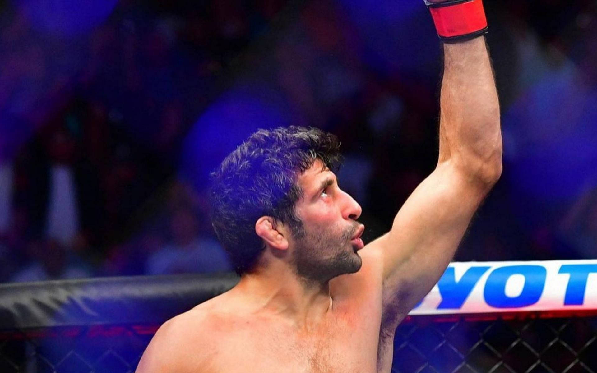 Beneil Dariush Raising His Victorious Left Arm After A Fight Background