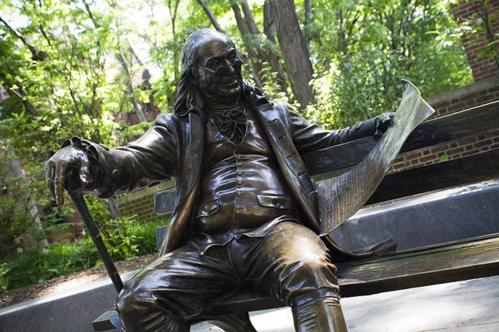 Benjamin Franklin Statue On A Bench Background