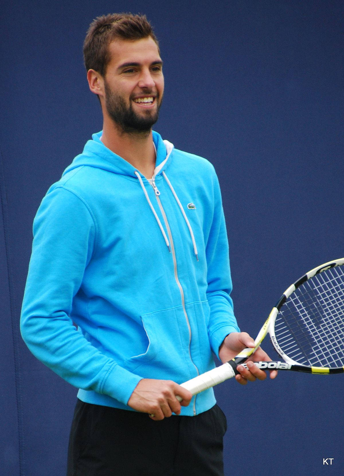 Benoit Paire Smiling While Holding Racket Background