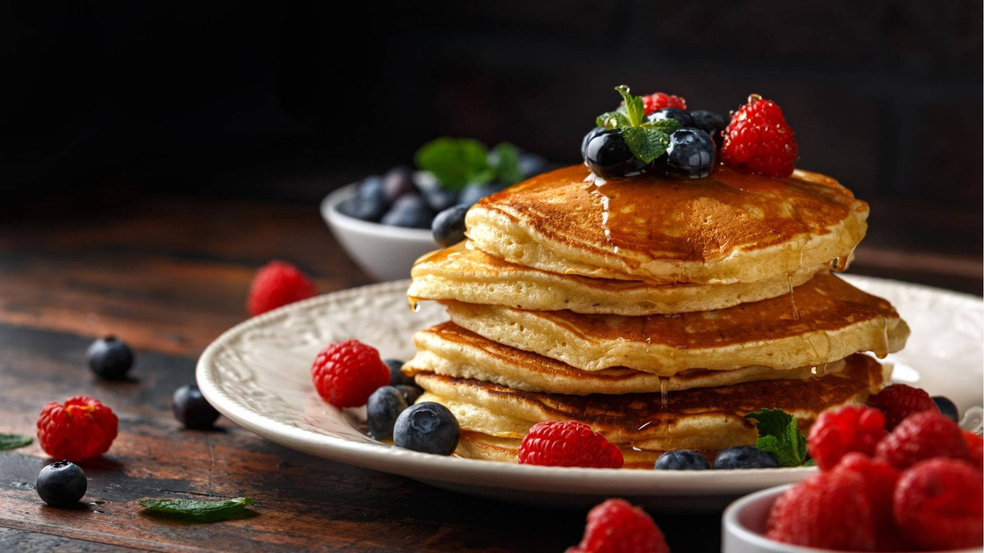 Berries And Honey On Pancakes Background
