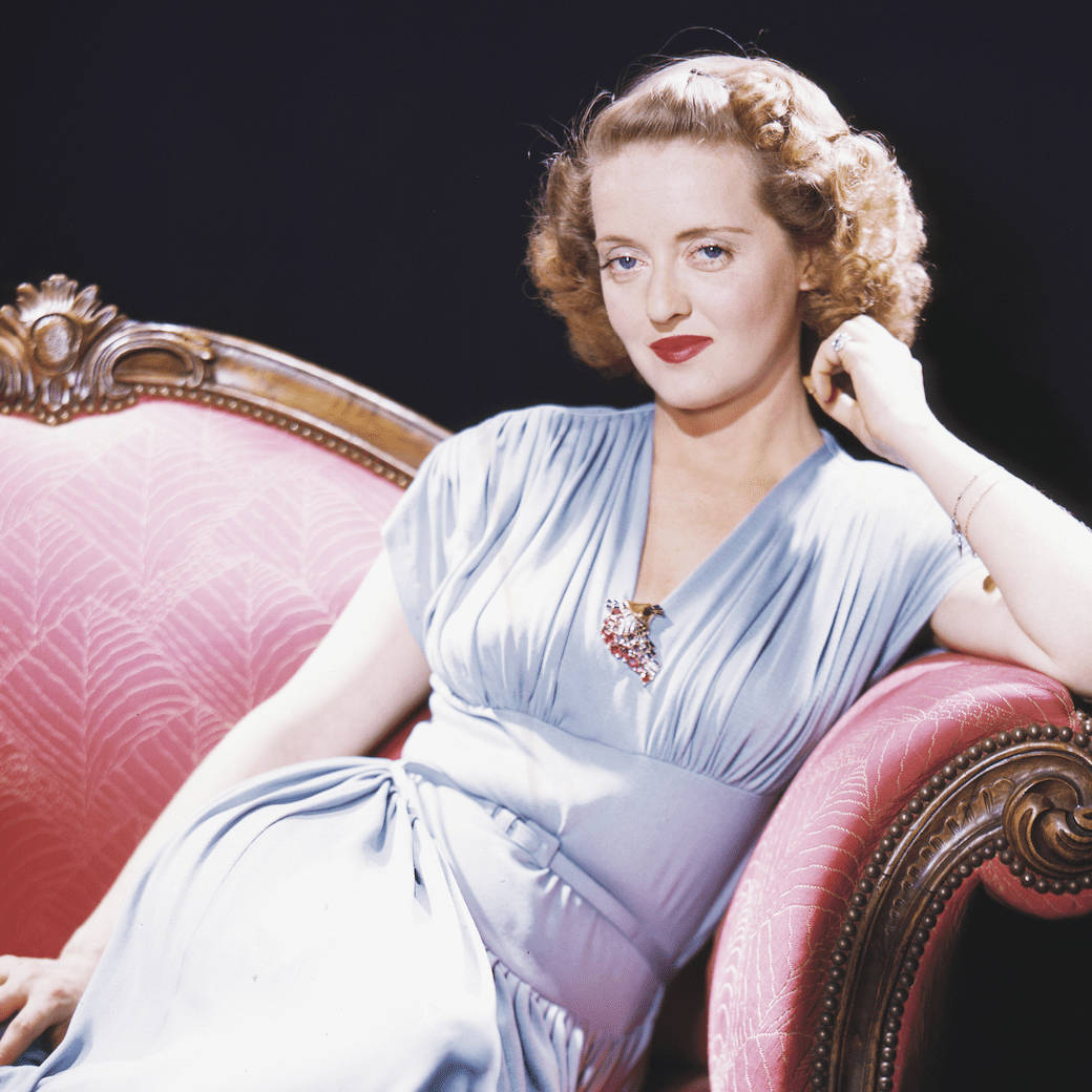 Bette Davis On Red Sofa Background