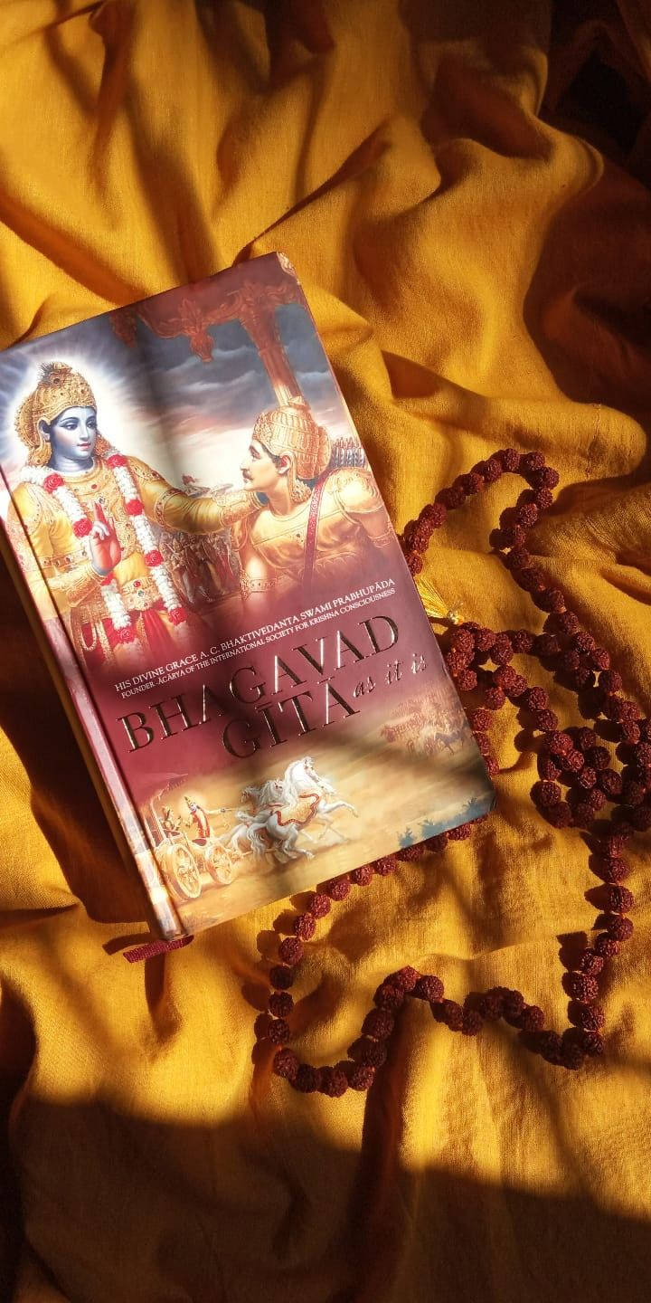 Bhagavad Gita As It Is On Yellow Cloth Background