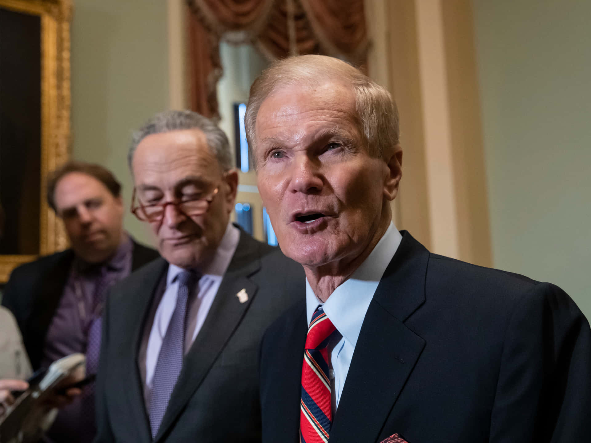 Bill Nelson In Black Suit And Red Tie Background