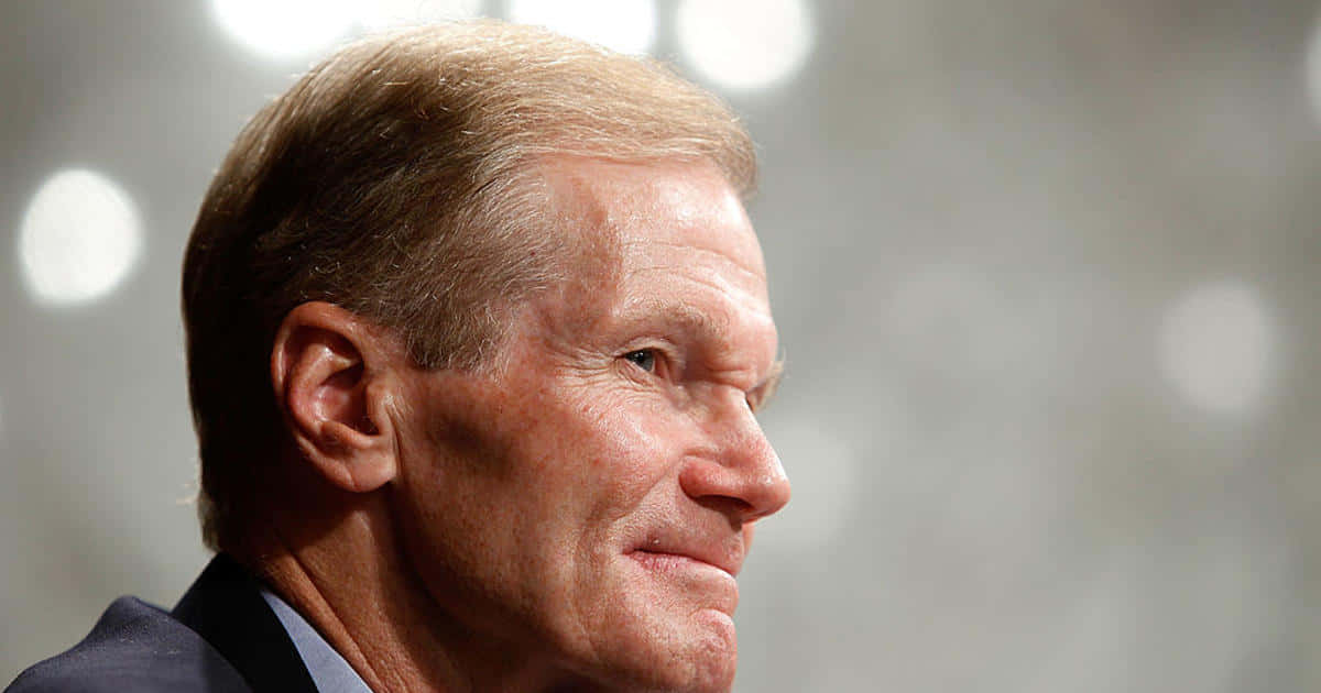 Bill Nelson Smiling With A Gray Backdrop Background