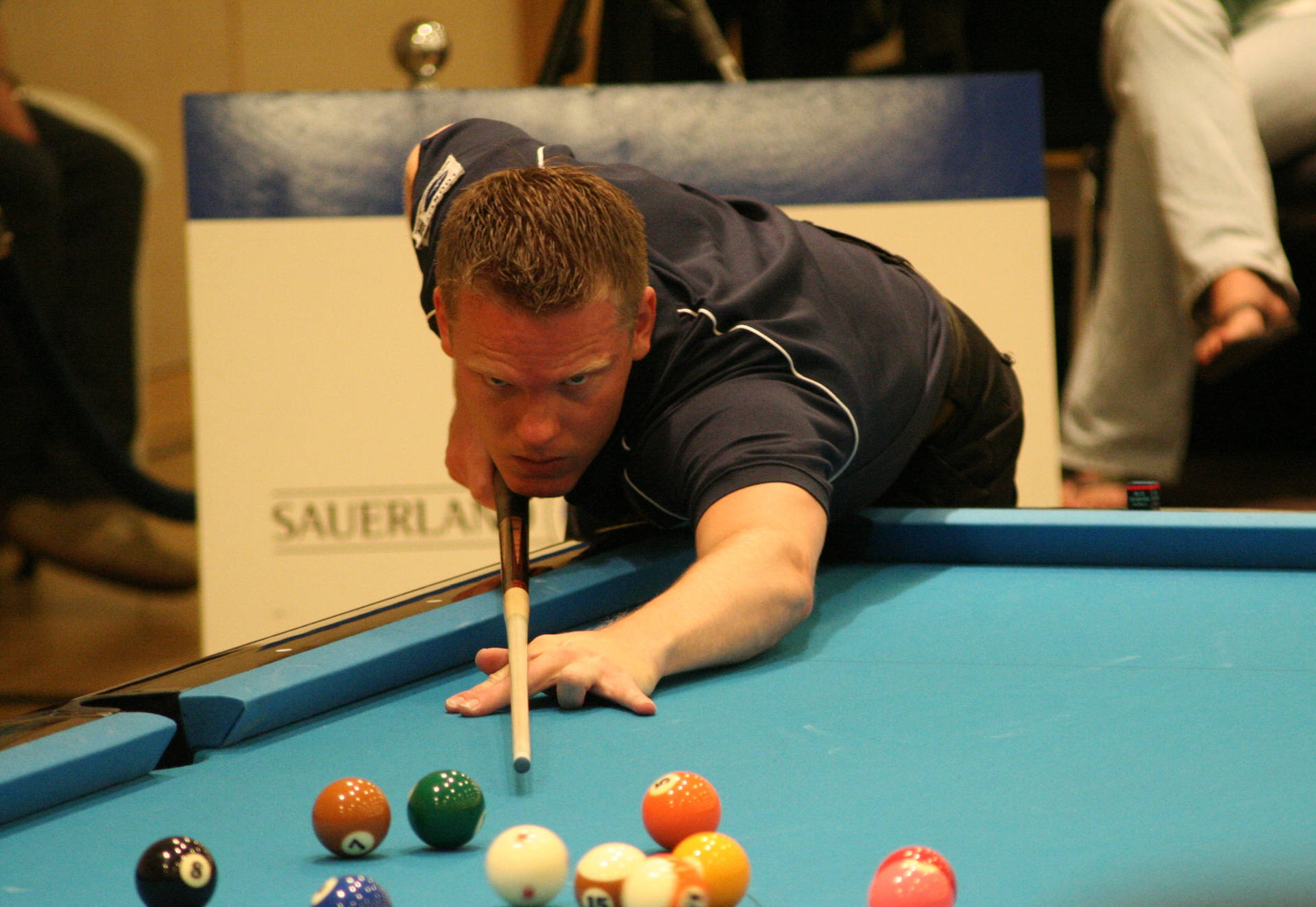 Billiards Athlete With Pool Stick On Blue Pool Table. Background