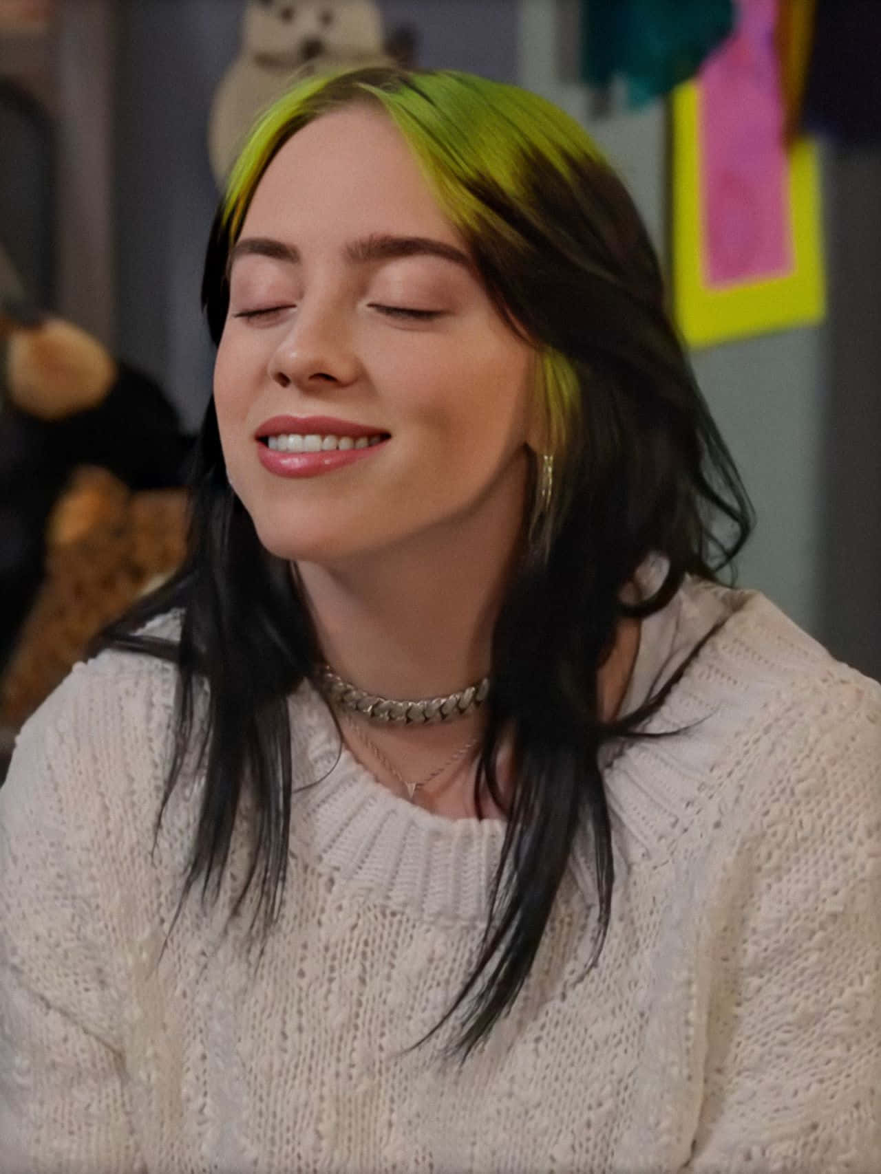 Billie Eilish Smiling With Her Signature Black And Green Hair Background