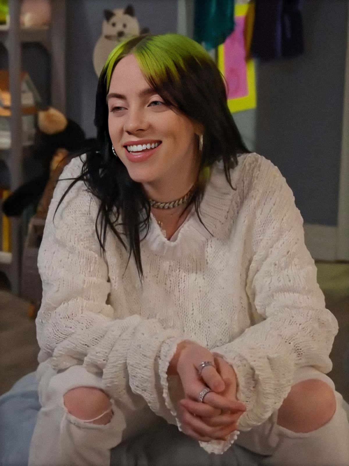 Billie Eilish Wearing Her Signature Green Hoodie And Smiling. Background