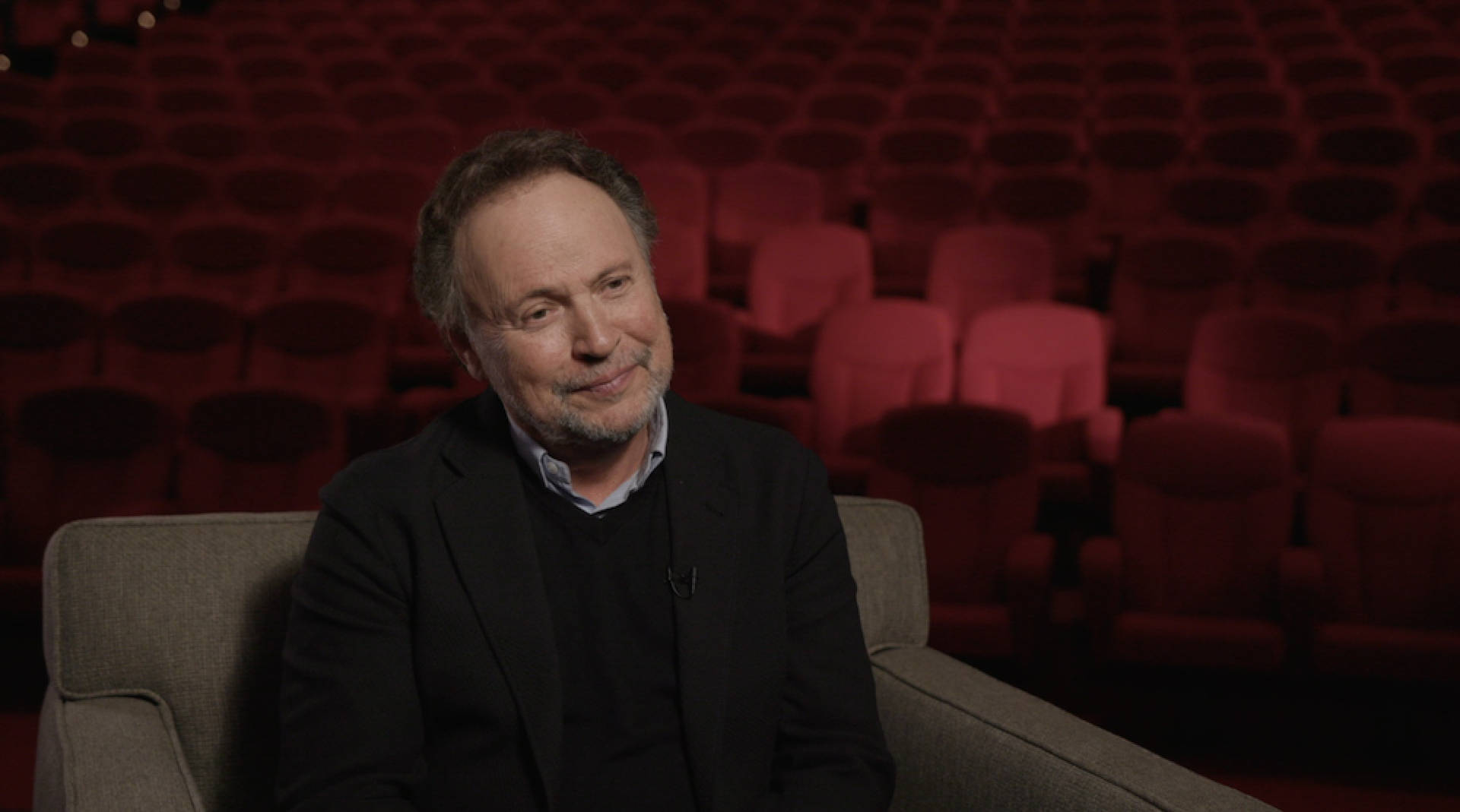 Billy Crystal During An Interview In An Ornate Movie Theatre Background