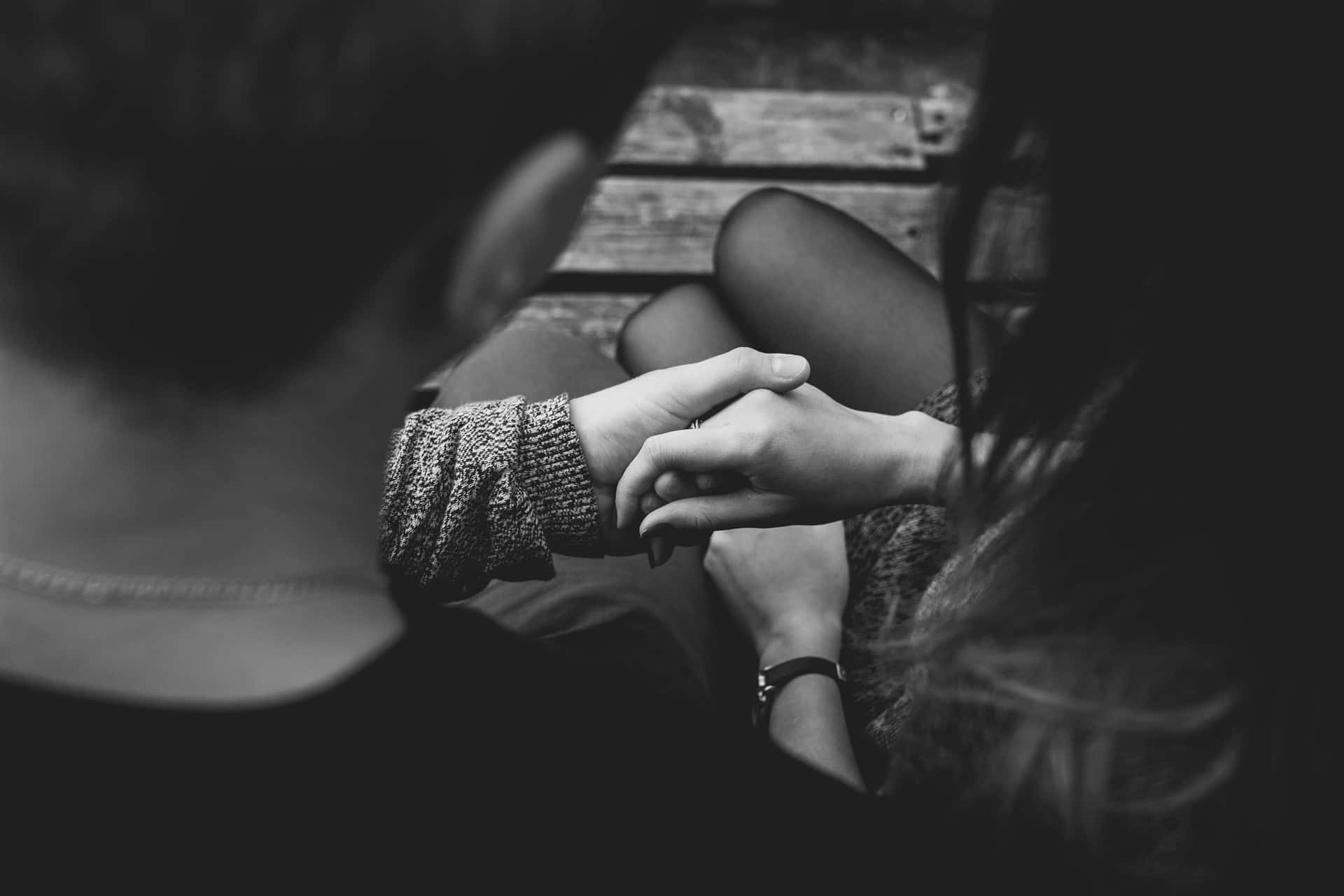 Black And White Shot Of A Couple Holding Each Other's Tangible Hands Background