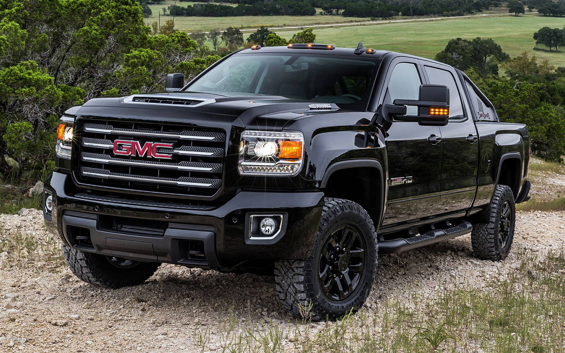 Black Duramax Climbing A Rocky Road Background