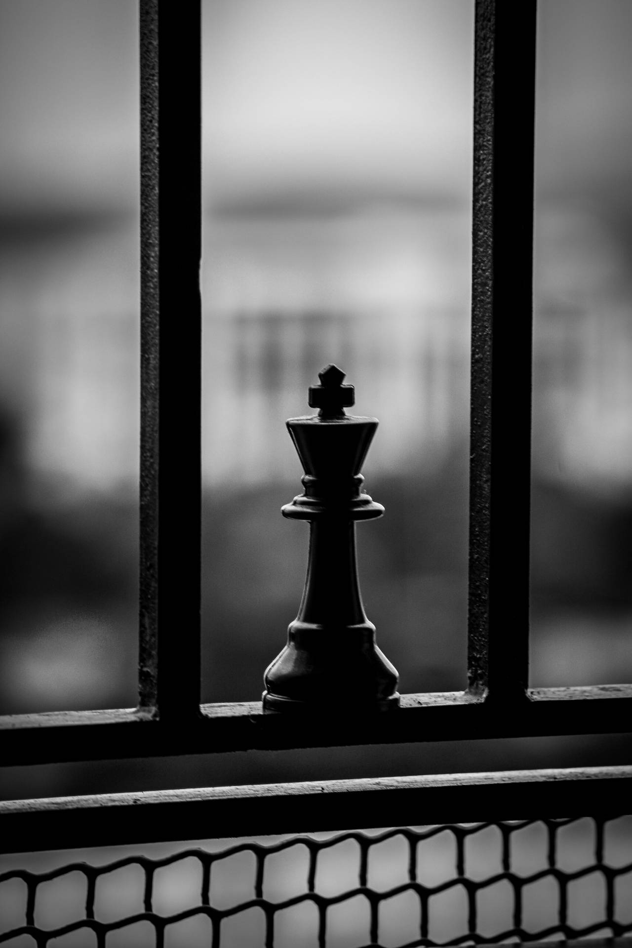 Black King Chess Piece On A Railing Background