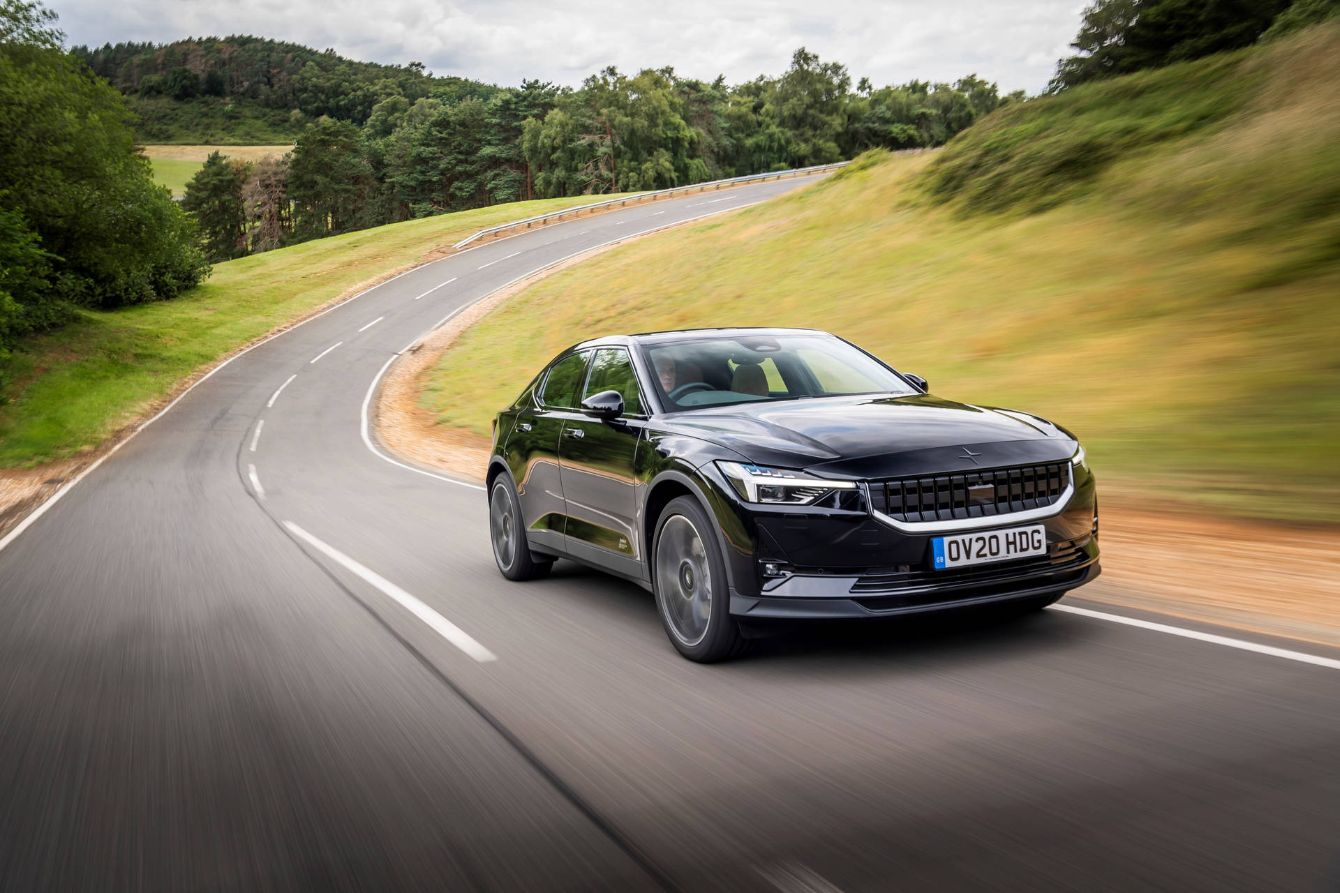 Black Polestar 2 Driving Through A Country Road Background