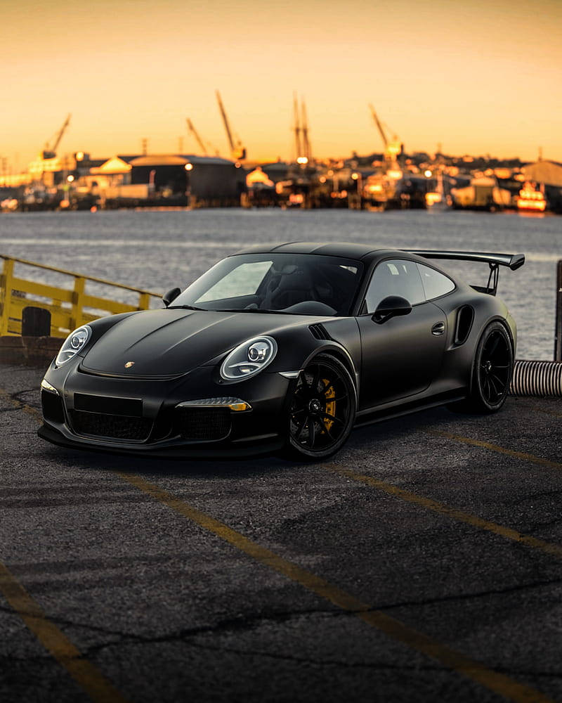 Black Porsche 911 By The Sea Background