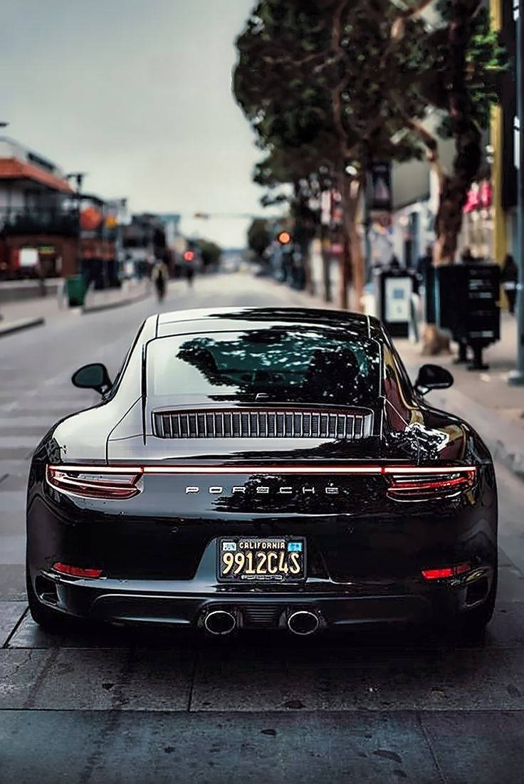 Black Porsche 911 Driving Around Town Background