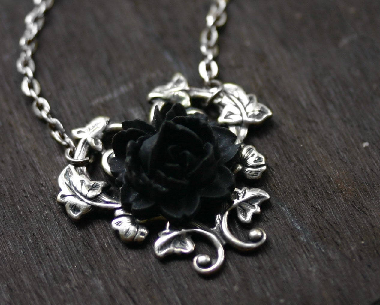 银色项链背景上的黑玫瑰