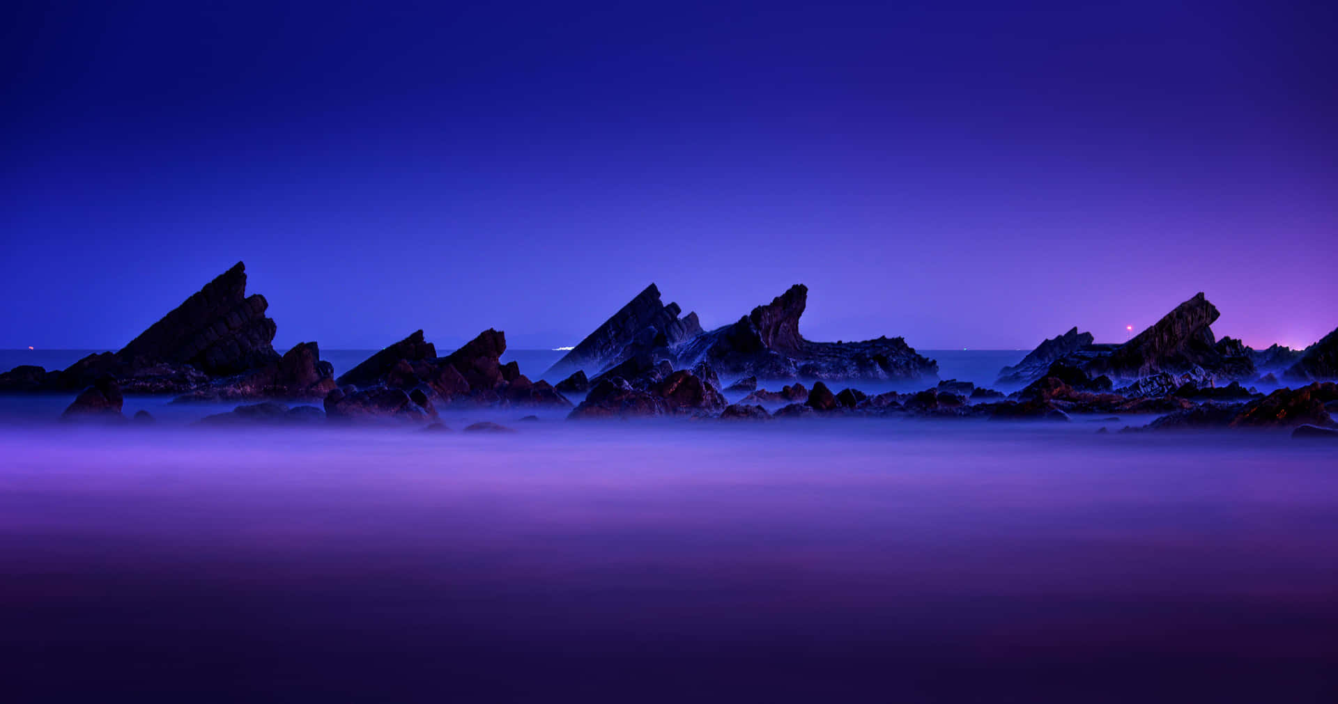 Blue And Purple Sunset With Rock Silhouettes Background