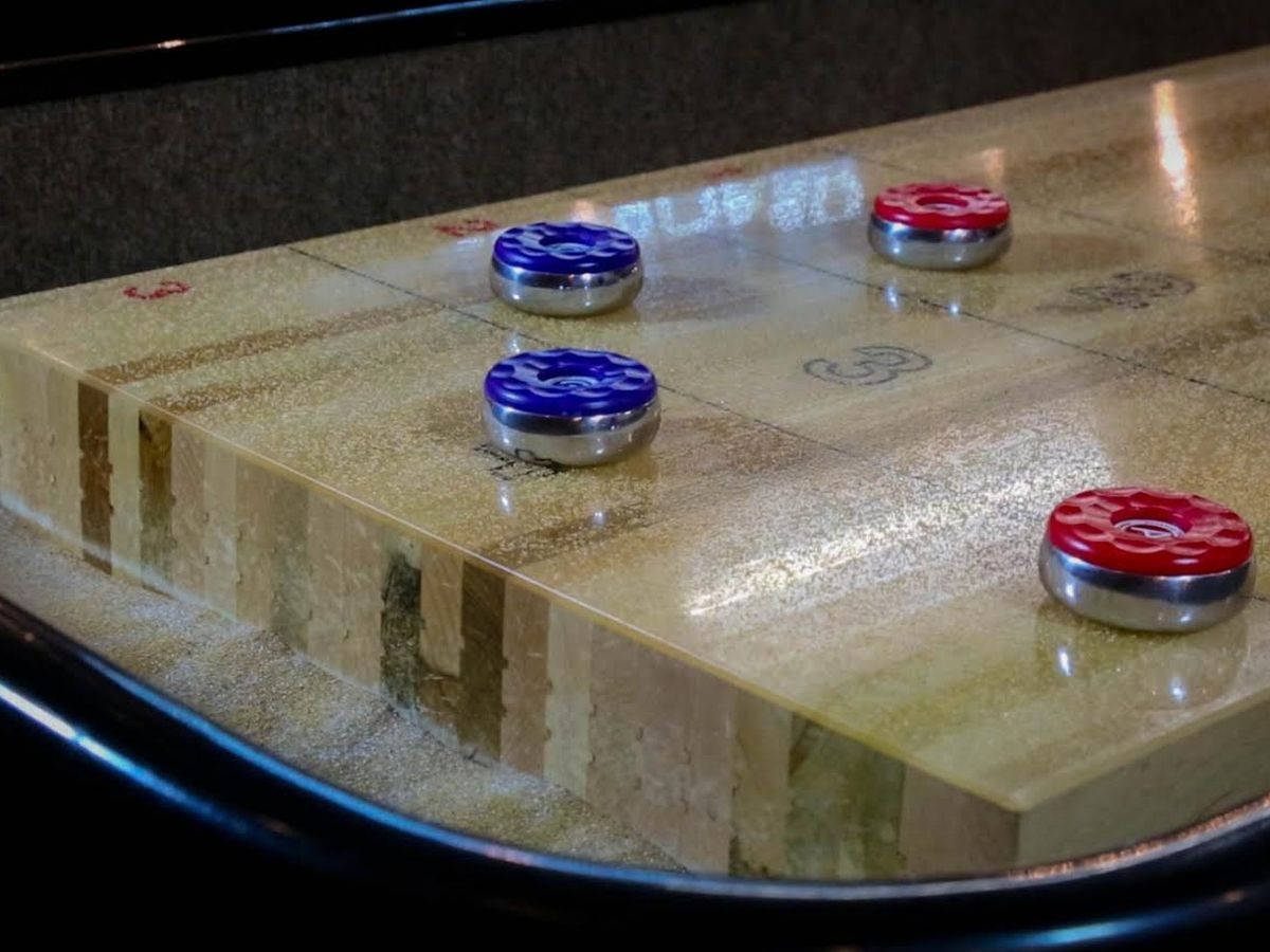 Blue And Red Pucks On Shuffleboard Table Background