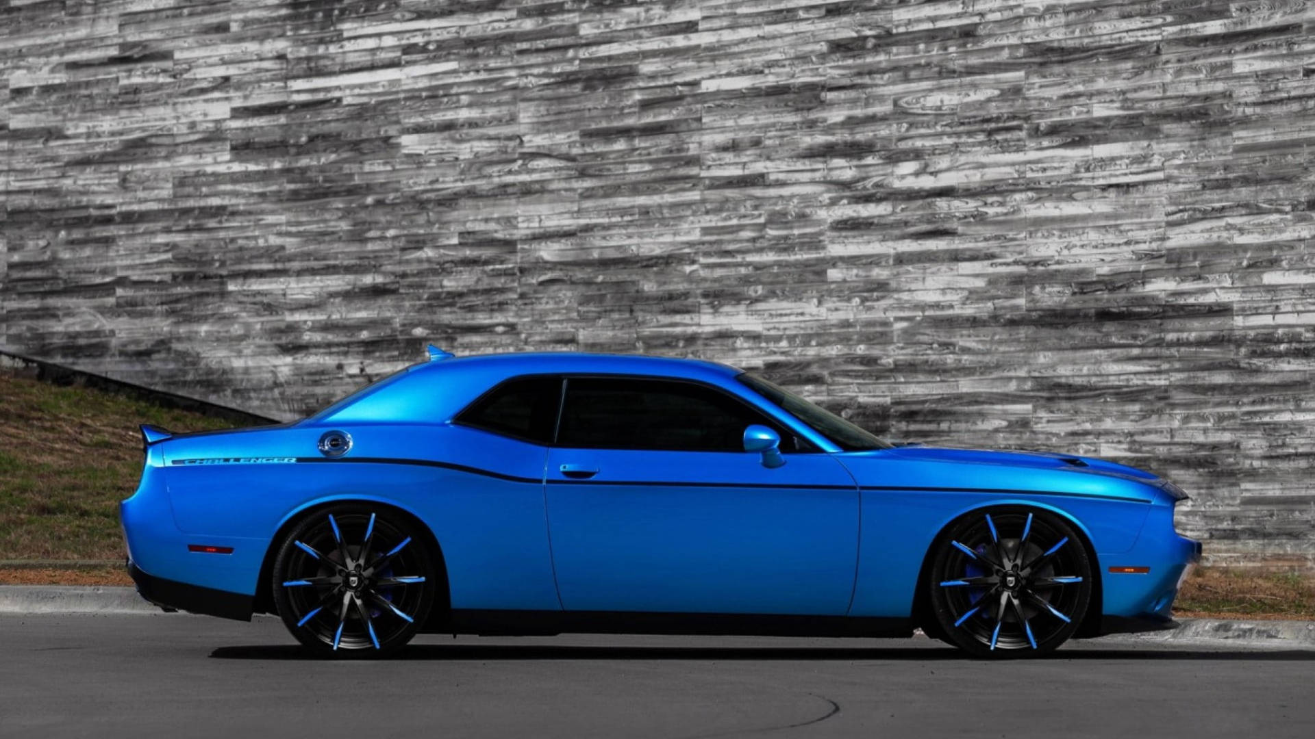 Blue Dodge Challenger Beside A Gray Wall Background