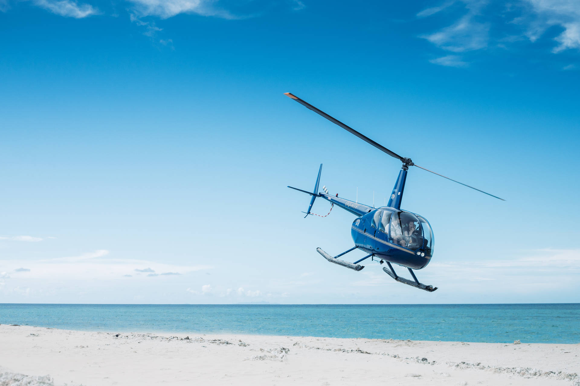 Blue Helicopter Landing On Sand Background