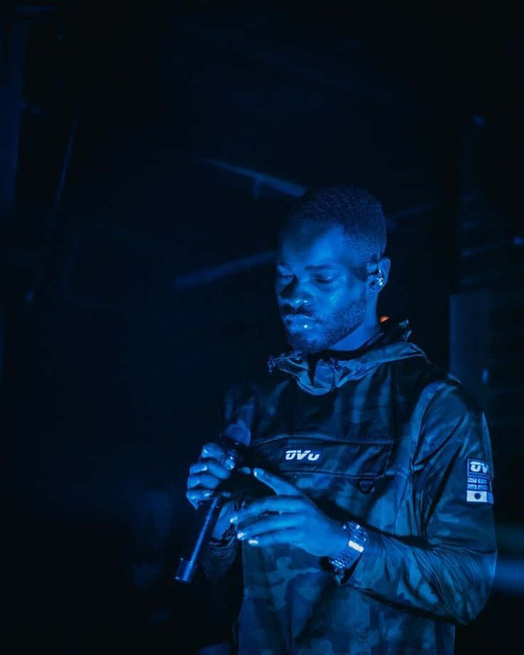 Blue Lit Performer On Stage Background
