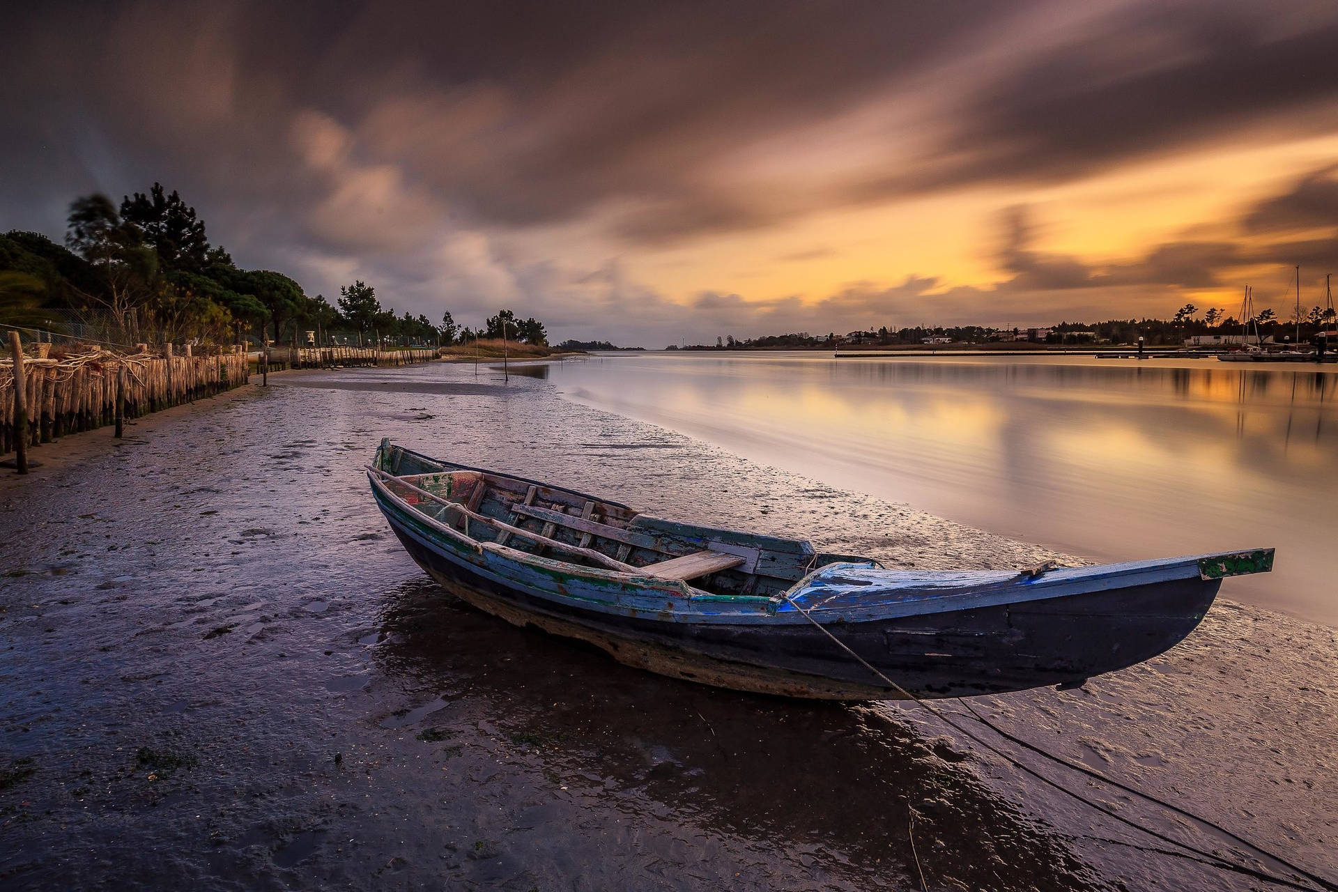 Boat Docked Along The Riverside Background