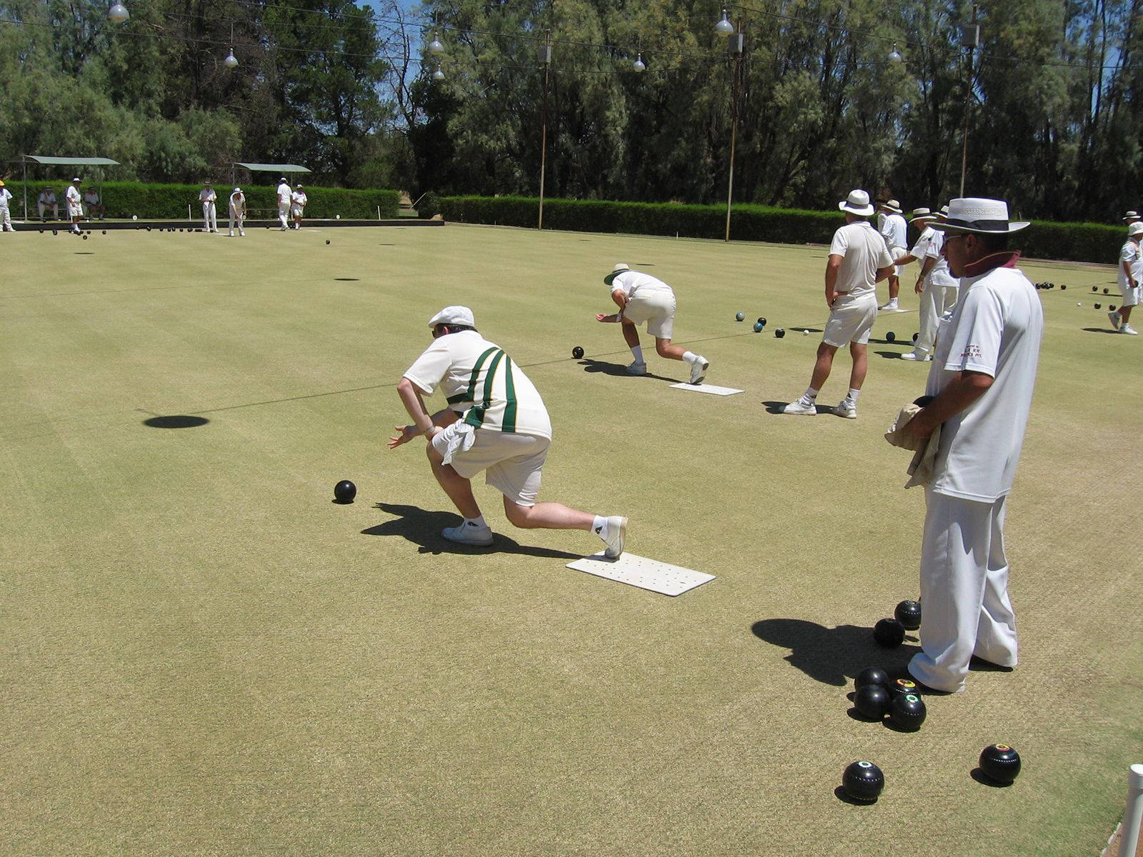 Bocce Ball Players In White On Grass Background