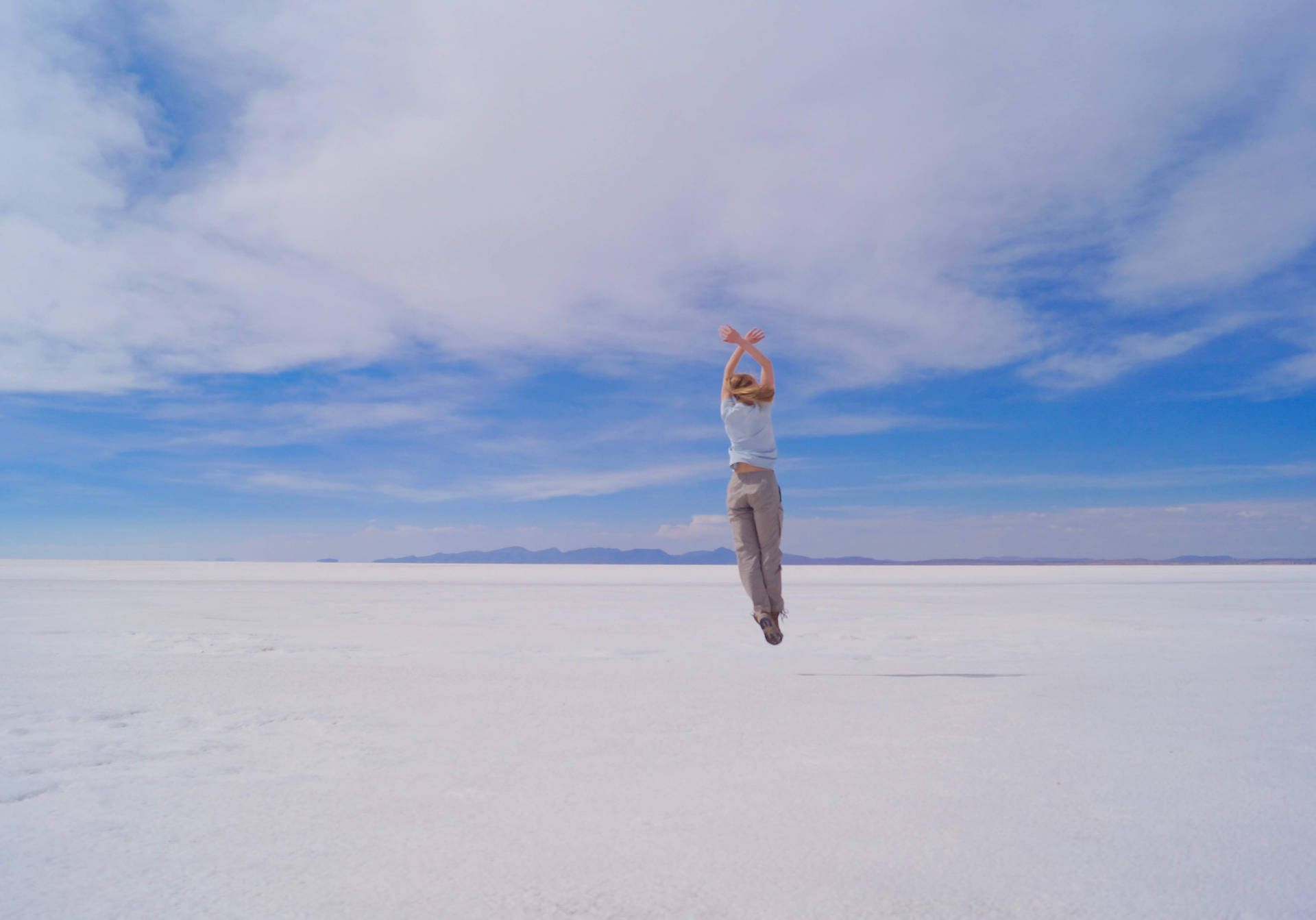 Bolivia Girl Jumping On Salt Plains Background