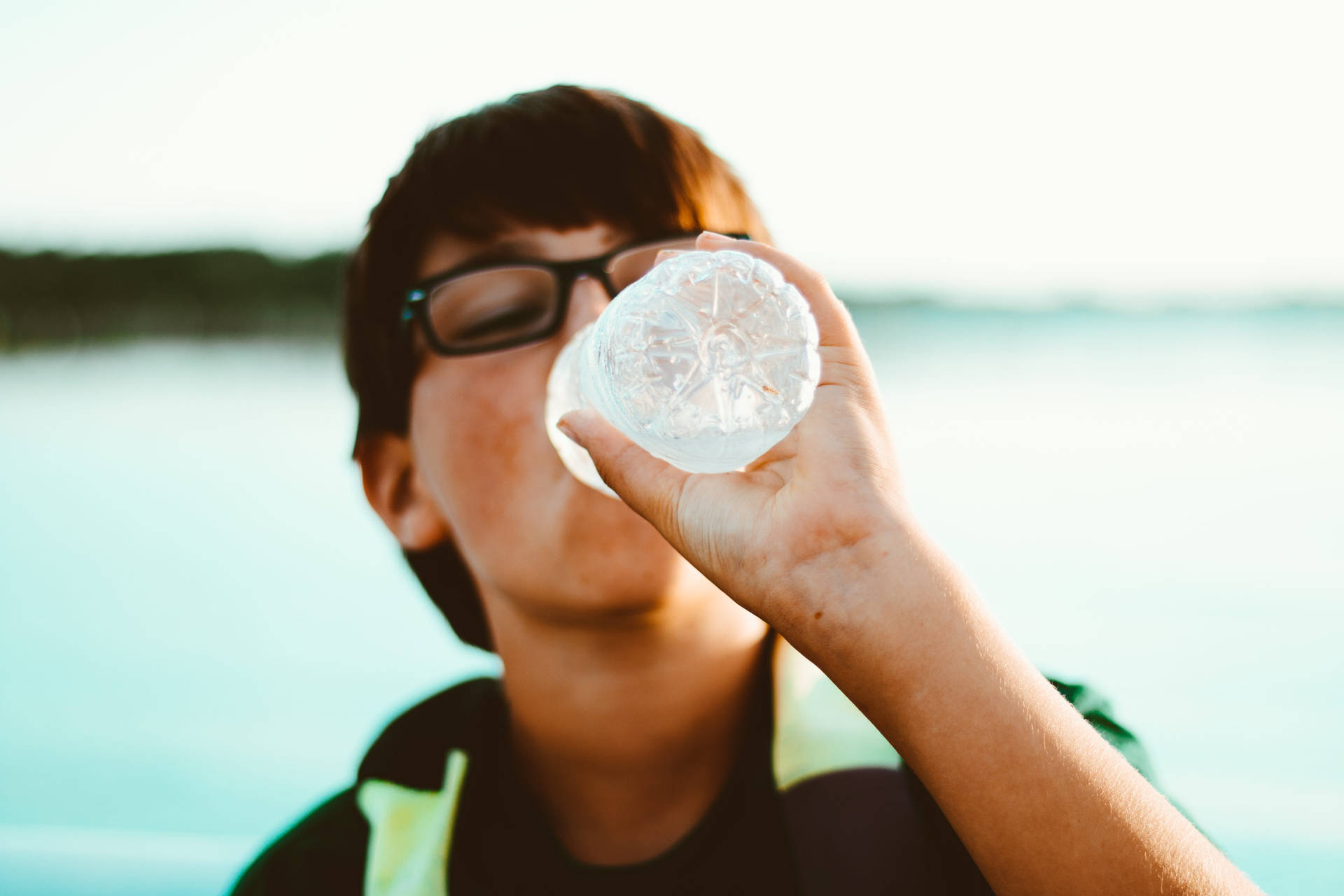 Boy With Glasses Drinking Water Background