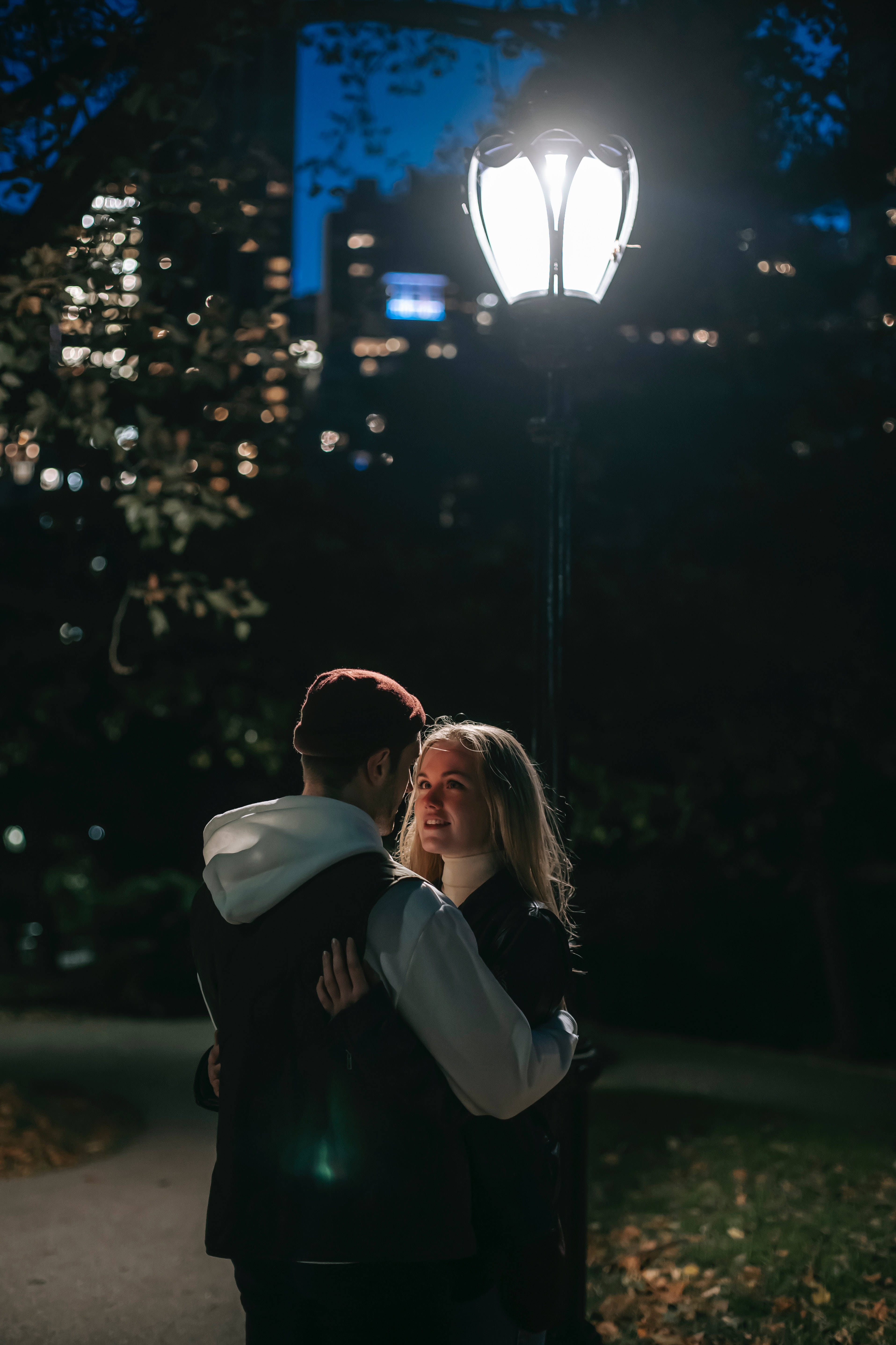 Boyfriend And Girlfriend Hugging By A Lamppost Background