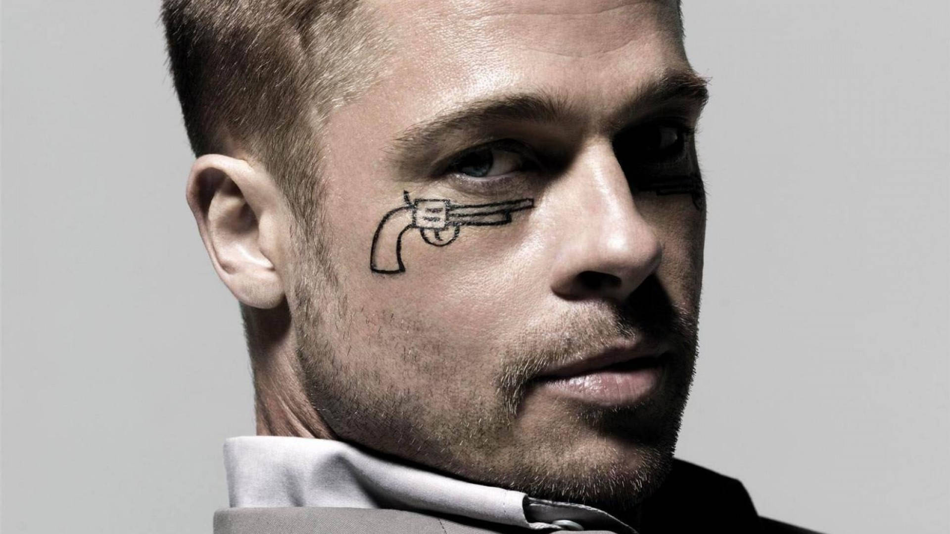 Brad Pitt Sporting A Gun Tattoo In His Eye Background