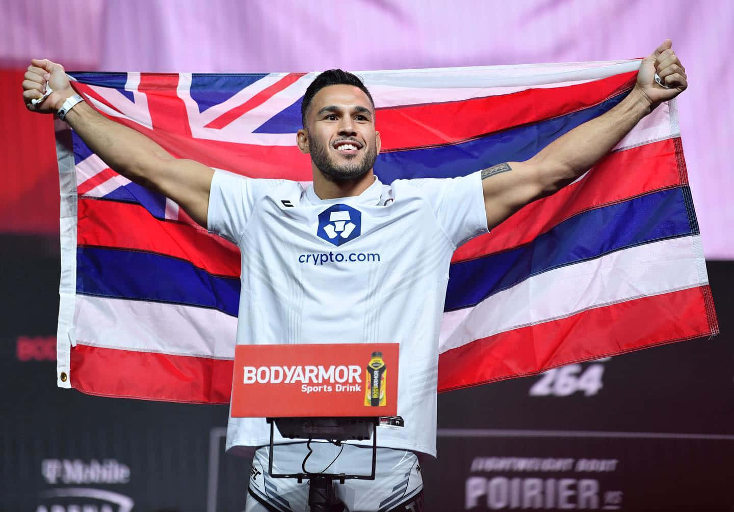 Brad Tavares Cheering And Smiling With A Flag Background