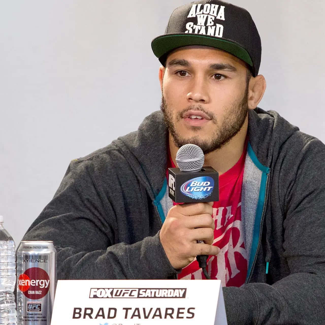 Brad Tavares Holding A Microphone Background