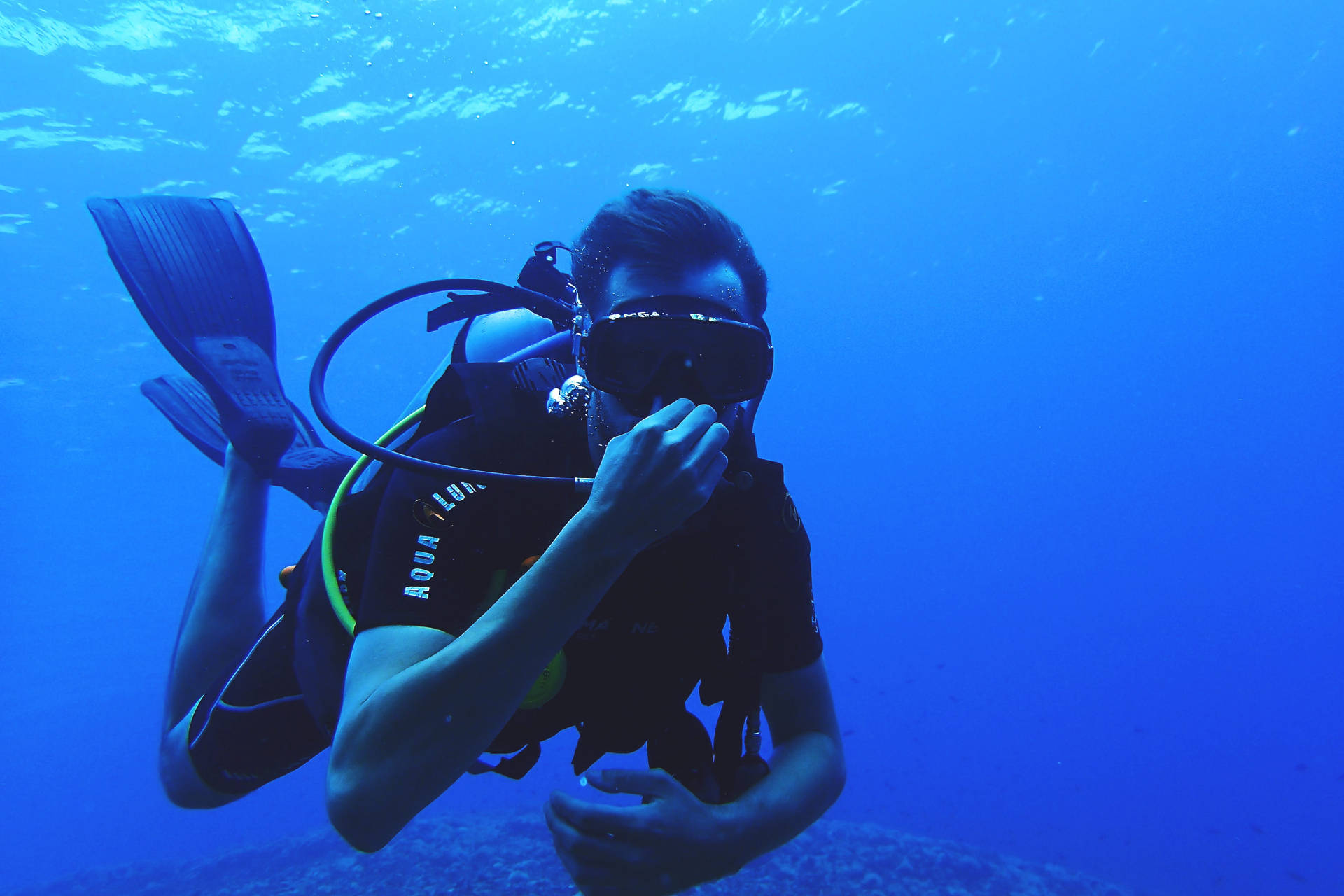 Breath-taking Scuba Diving Adventure Under The Deep Blue Oceans Background