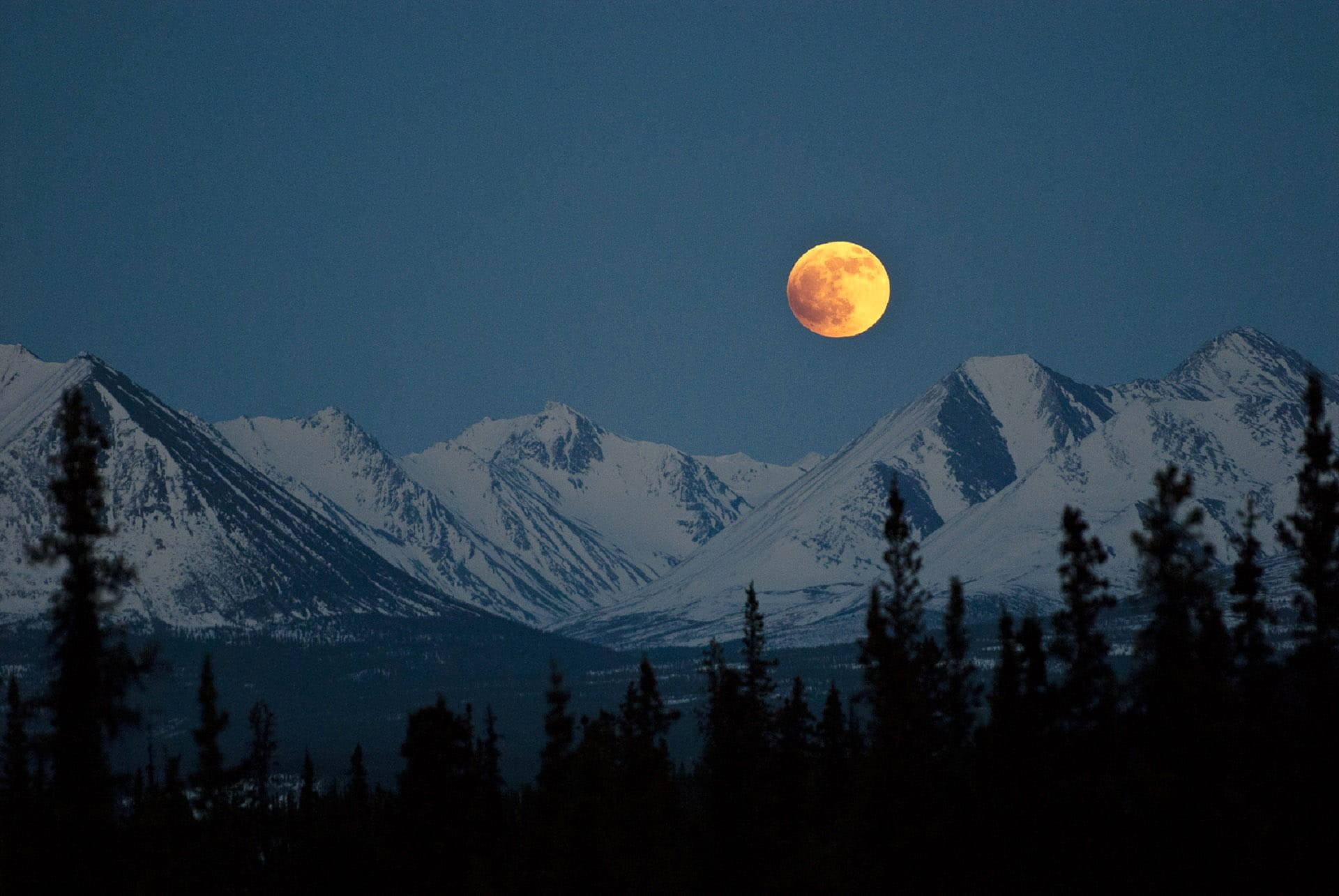 Breathtaking View Of A Full Moon Over Denali Mountains