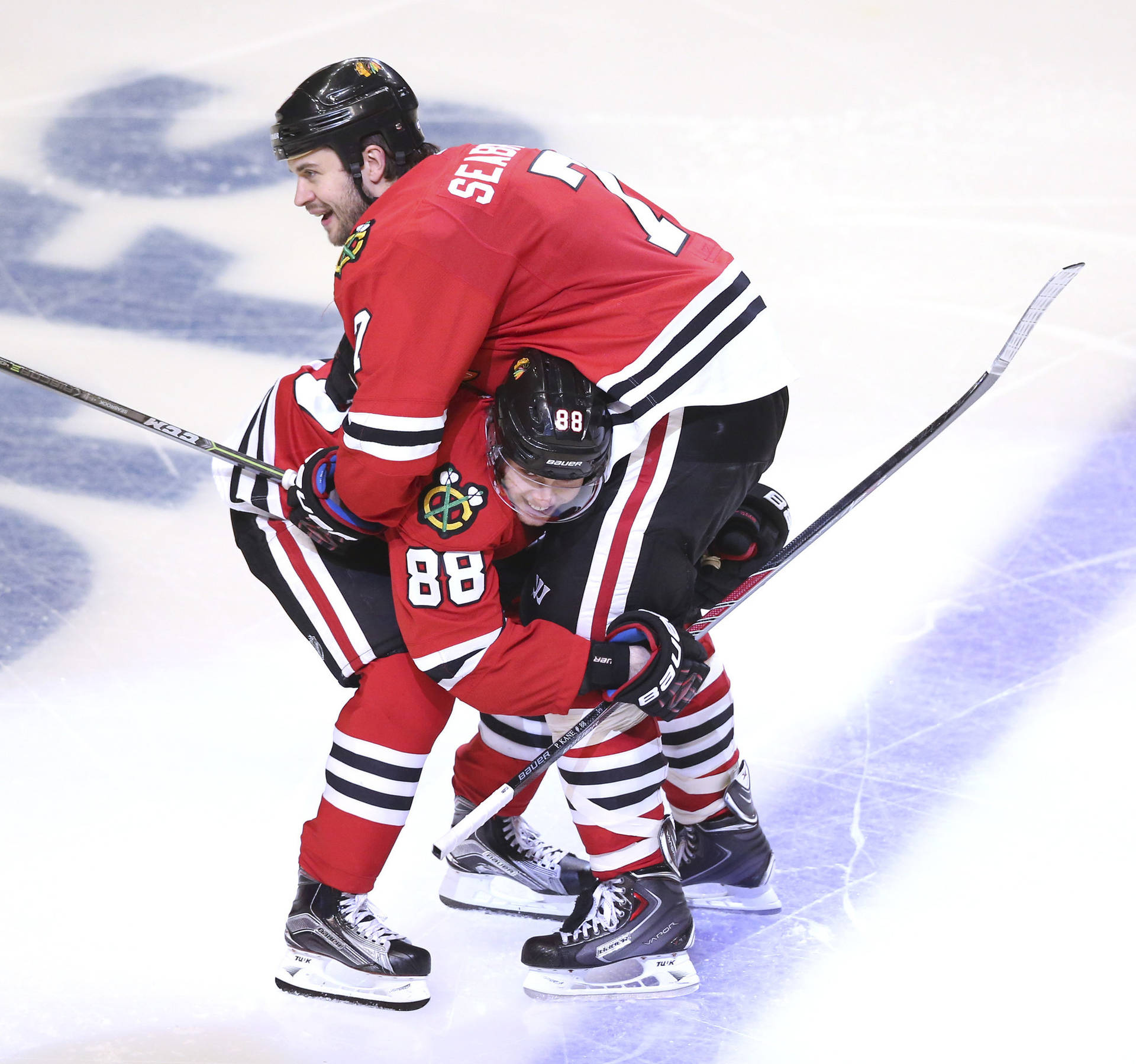 Brent Seabrook And Patrick Kane Celebrating On The Ice Background