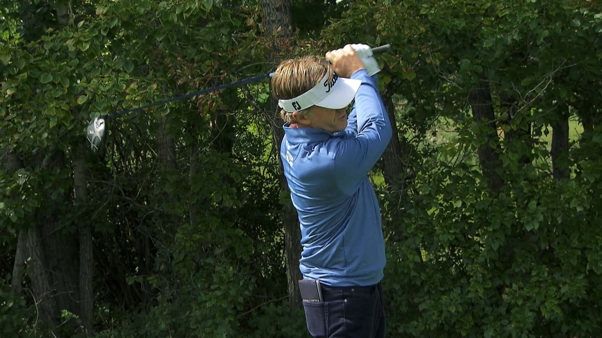 Brett Quigley Golfing By Leafy Tree Background