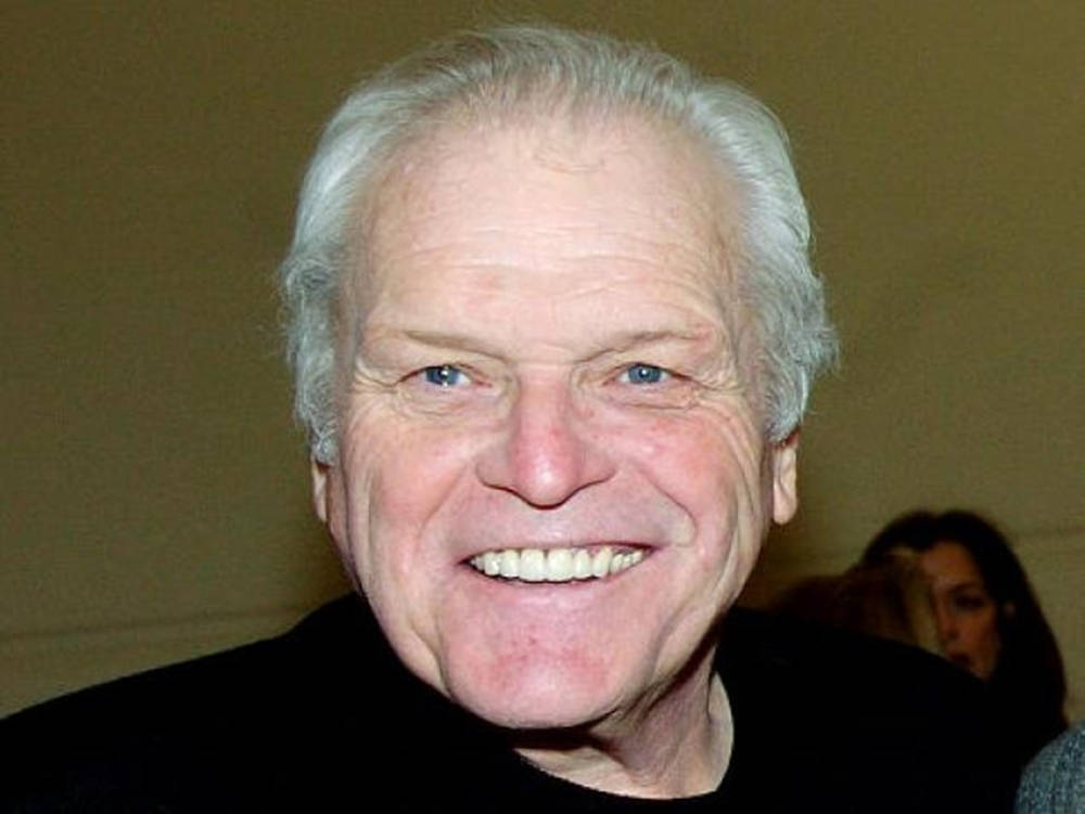 Brian Dennehy Smiling On Brown Background Background