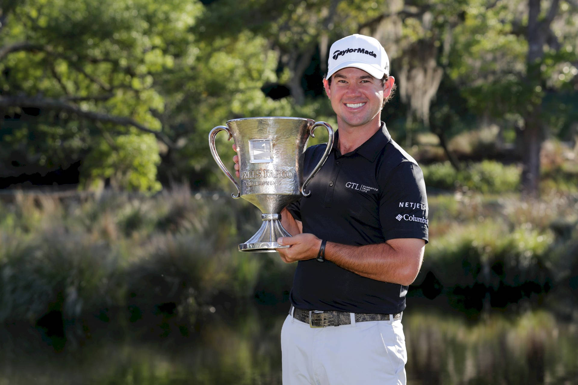 Brian Harman Holding A Prestigious Golf Trophy Triumphantly. Background