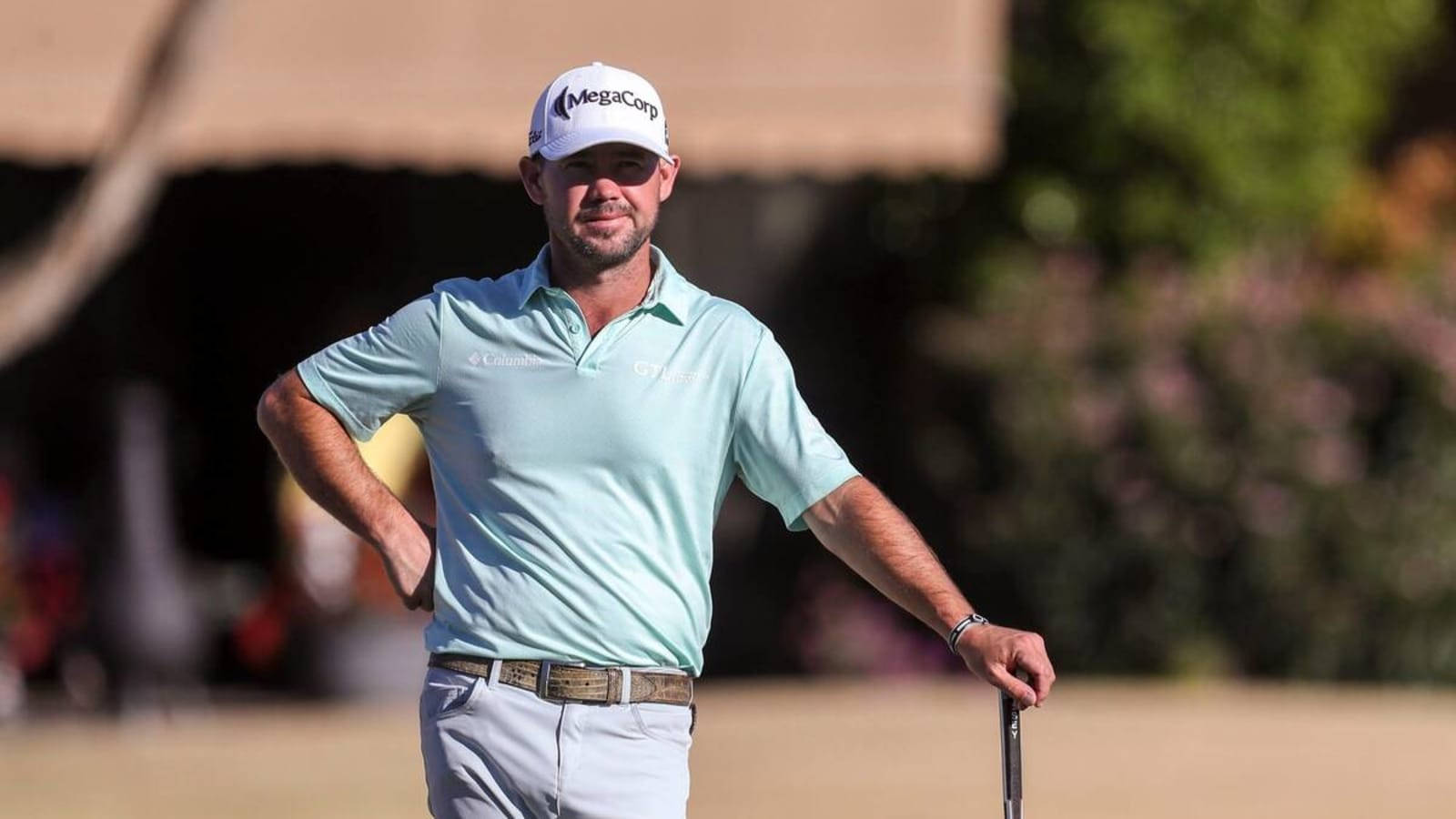 Brian Harman Leaning On Golf Club Background