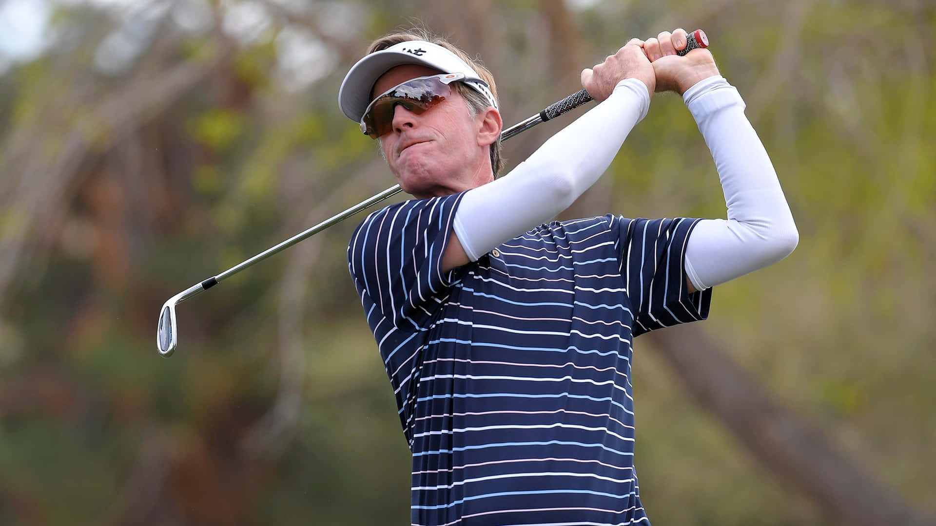 Briny Baird Practicing His Swing In A Sunny Golf Course Background