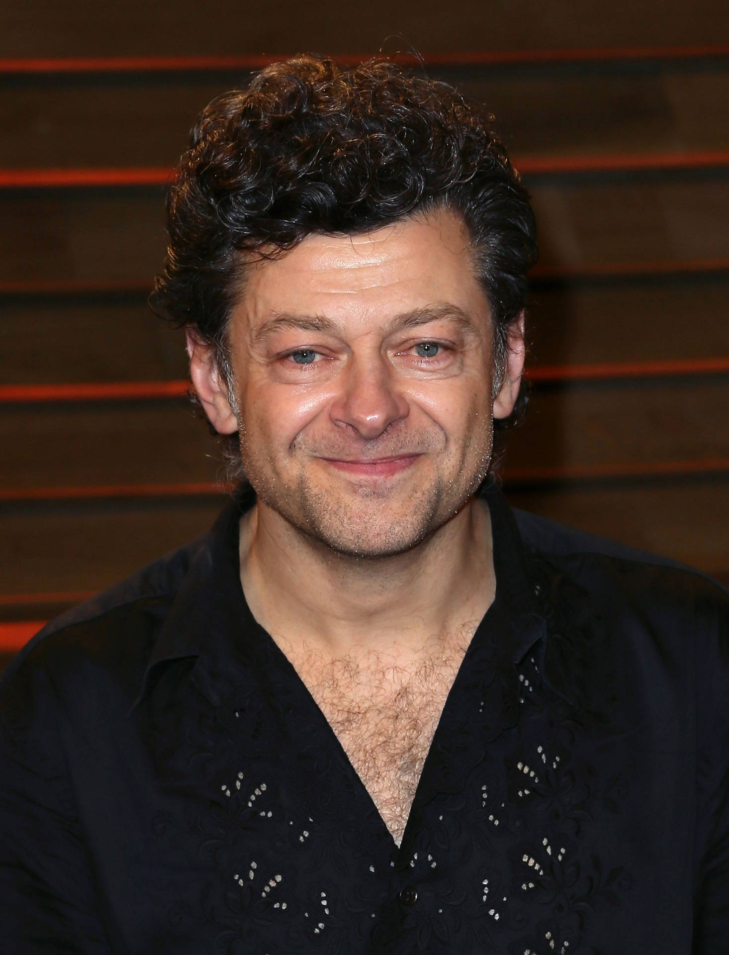 British Actor Andy Serkis Delivering An Invigorating Speech On Stage Background